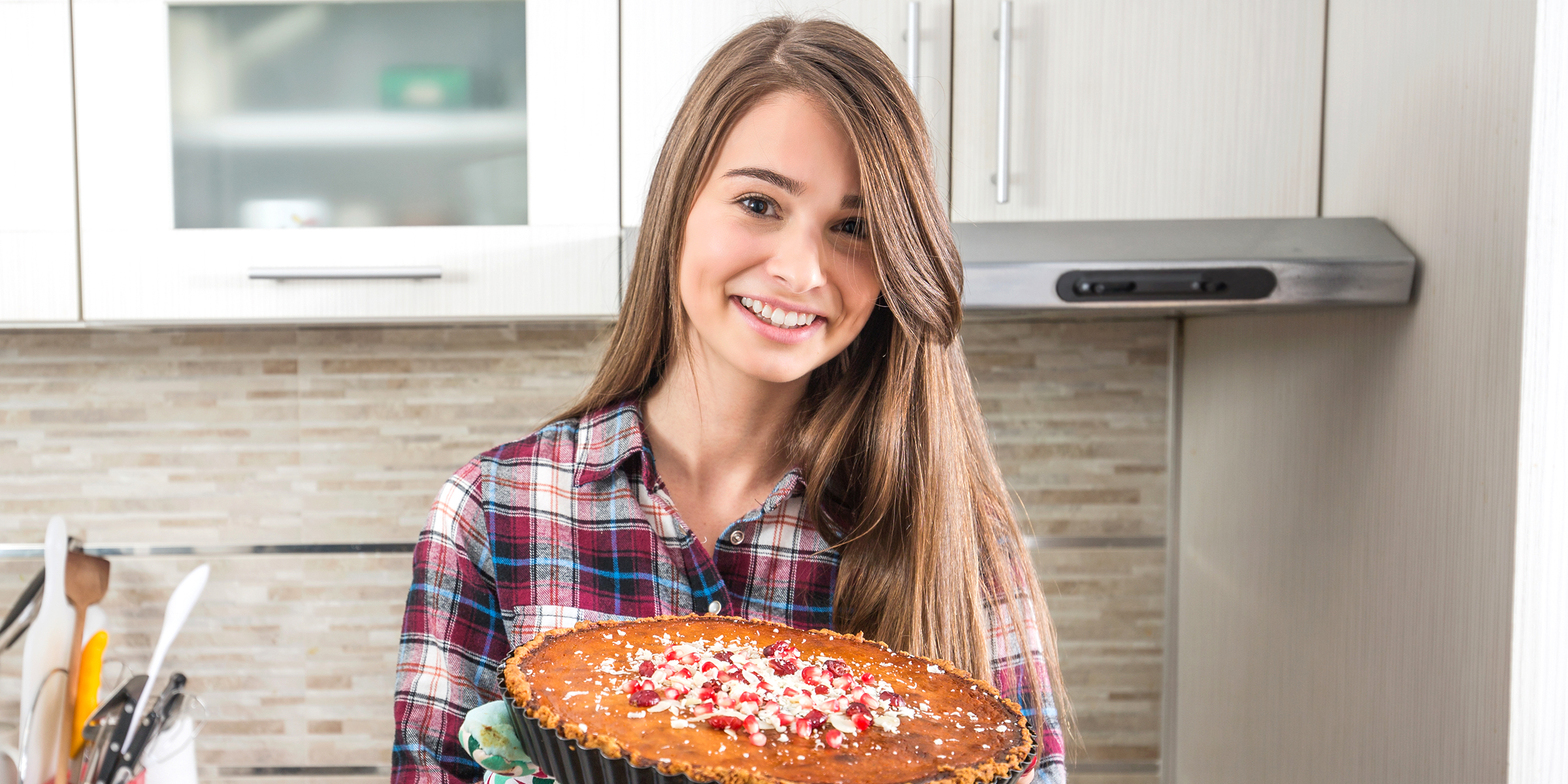 Eine lächelnde Frau, die einen Kuchen hält | Quelle: Shutterstock