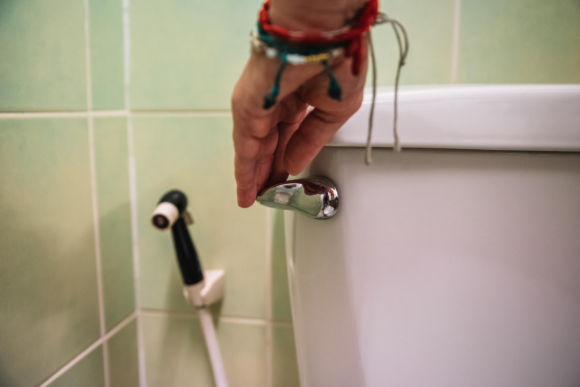 Nahaufnahme einer Hand, die eine Toilette spült | Quelle: Getty Images