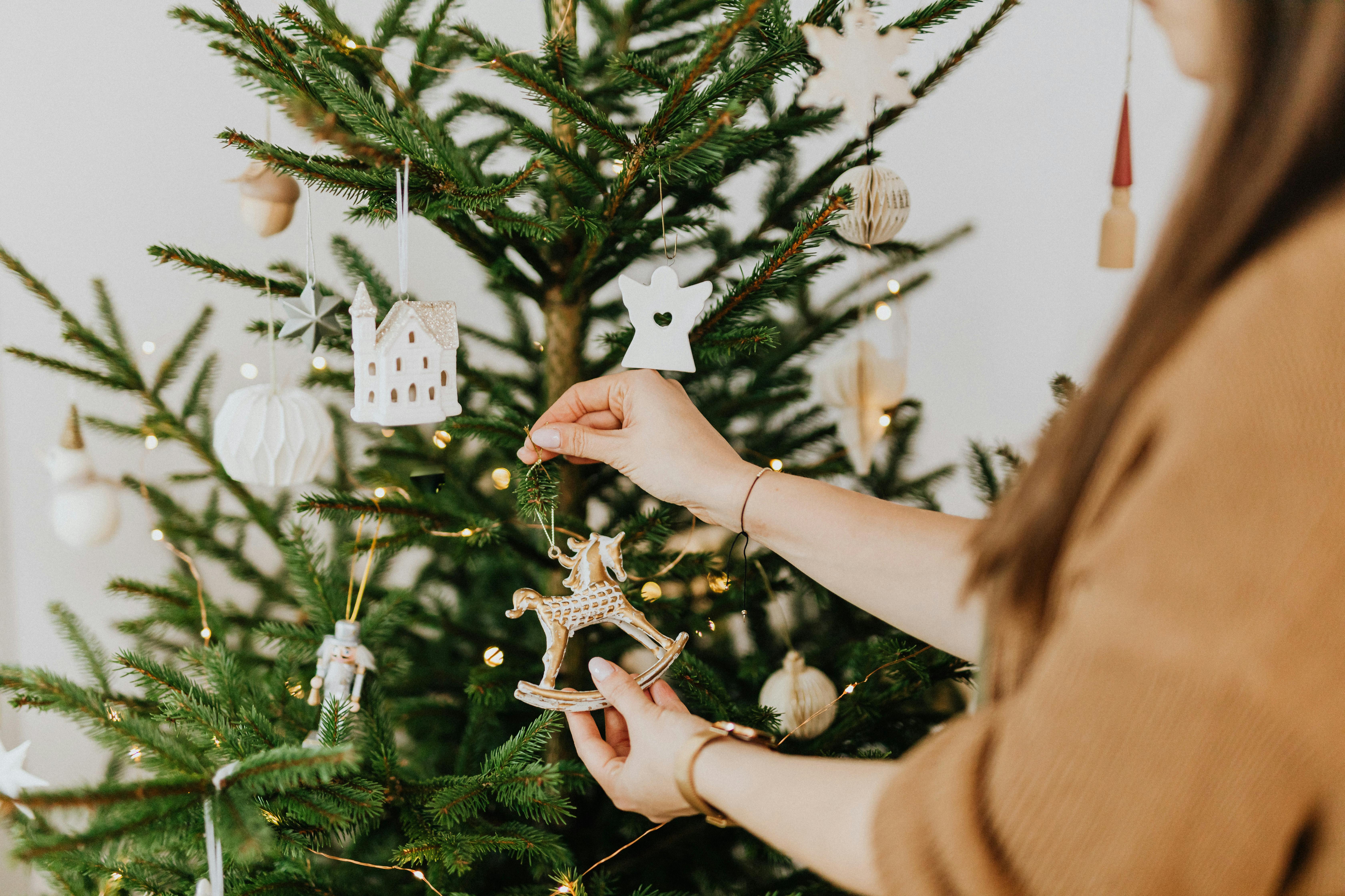 Eine Frau schmückt einen Weihnachtsbaum | Quelle: Pexels