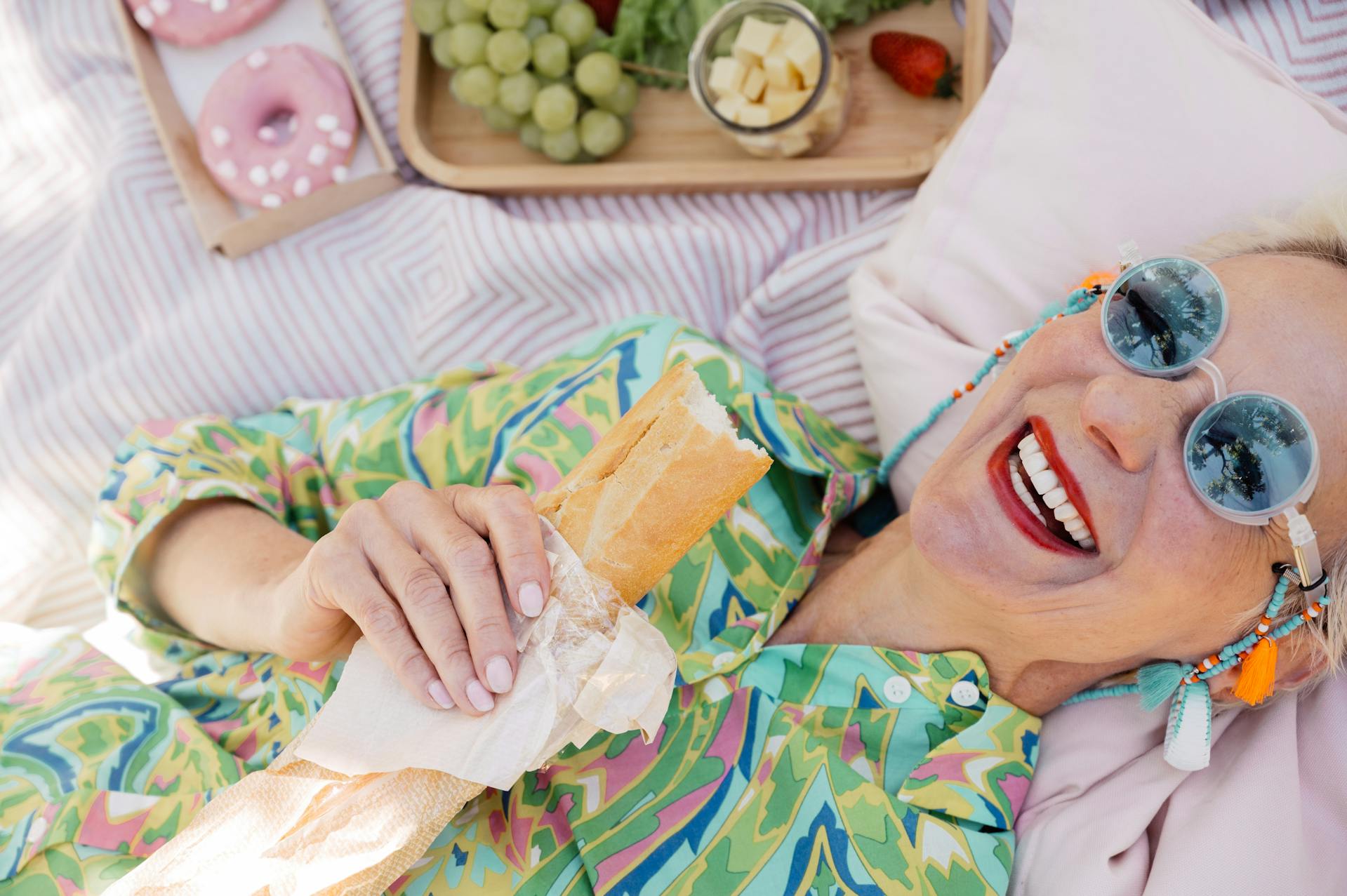 Eine ältere Frau, die sich hinlegt und einen Burger in der Hand hält | Quelle: Pexels