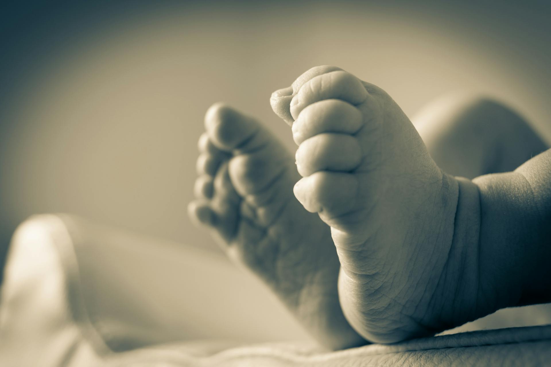 Ein Graustufenfoto der Füße eines neugeborenen Babys | Quelle: Pexels