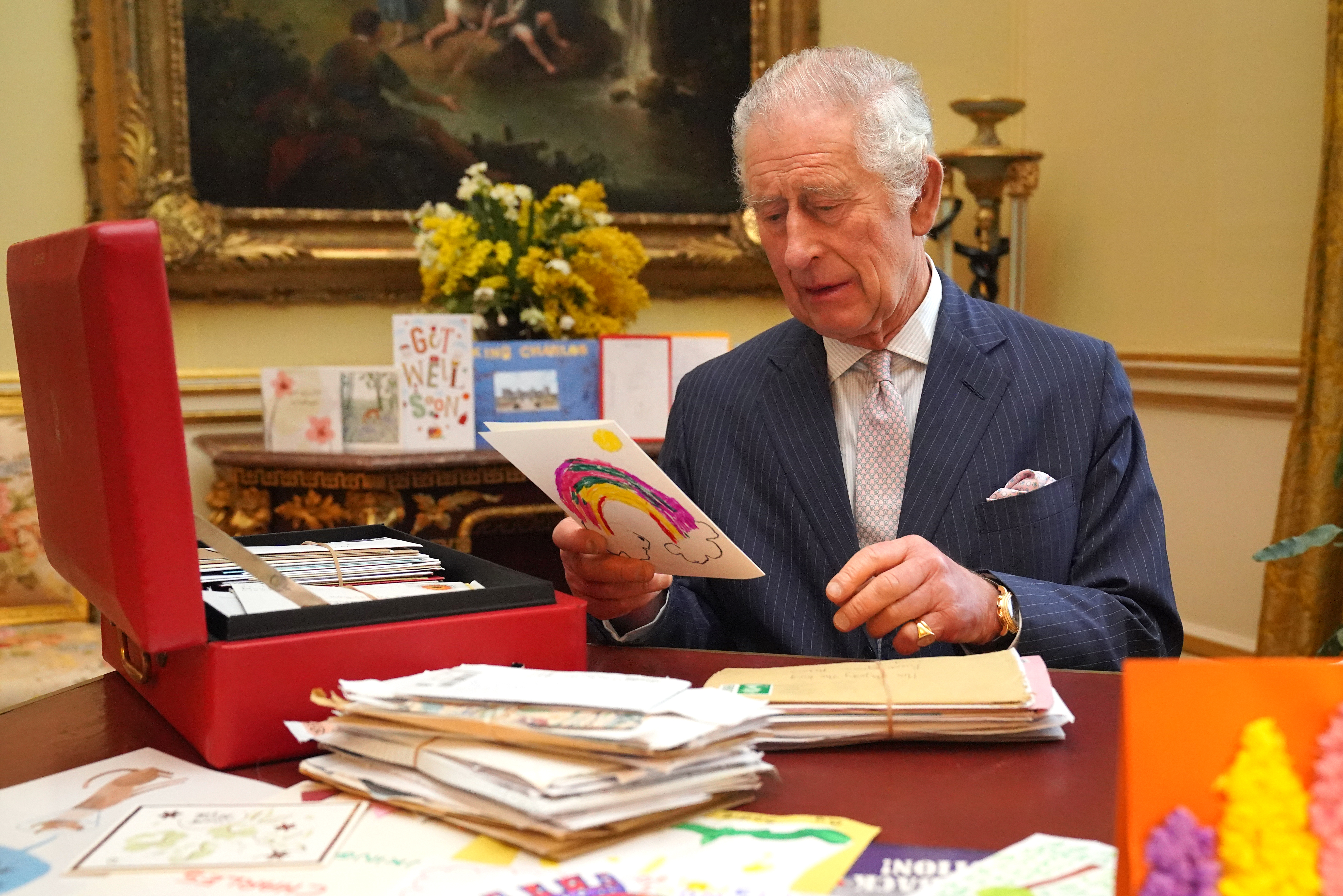 König Charles liest Karten, die ihm Gratulanten nach seiner Krebsdiagnose geschickt haben, im Saal des 18. Jahrhunderts in der Belgischen Suite im Buckingham Palace am 21. Februar 2024 in London, England | Quelle: Getty Images