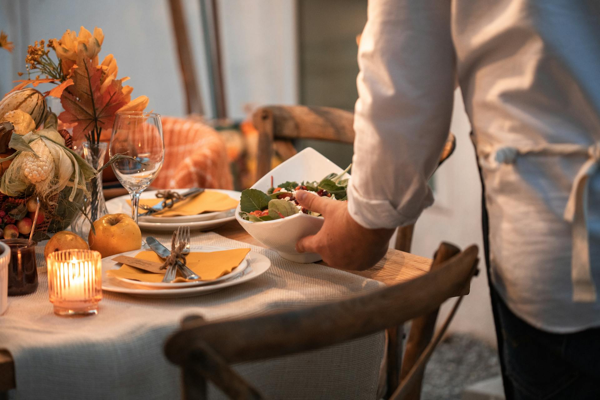 Eine Person in einem weißen Hemd hält einen weißen Keramikteller mit Essen | Quelle: Pexels