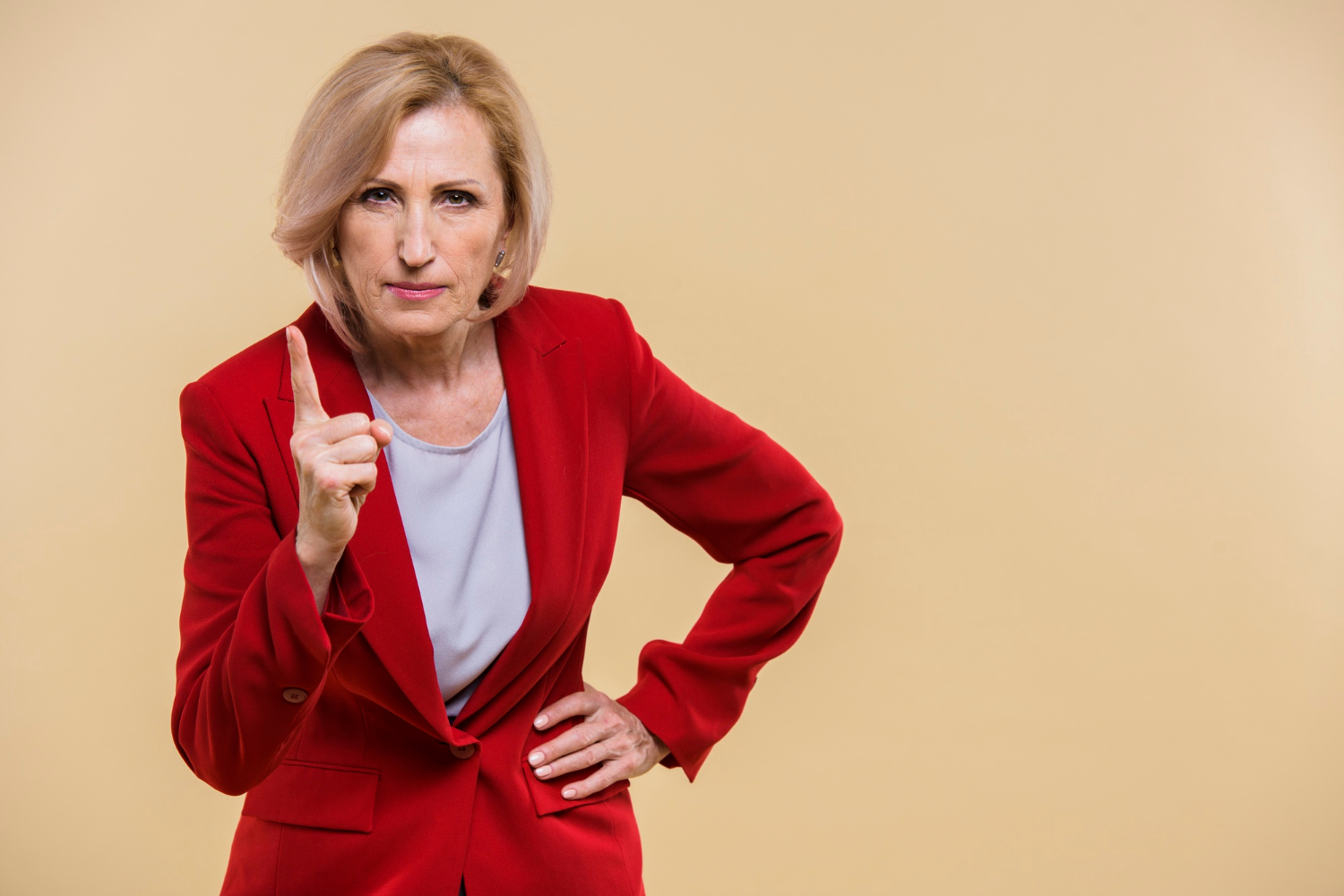 Eine ernste ältere Frau, die mit dem Finger zeigt | Quelle: Freepik