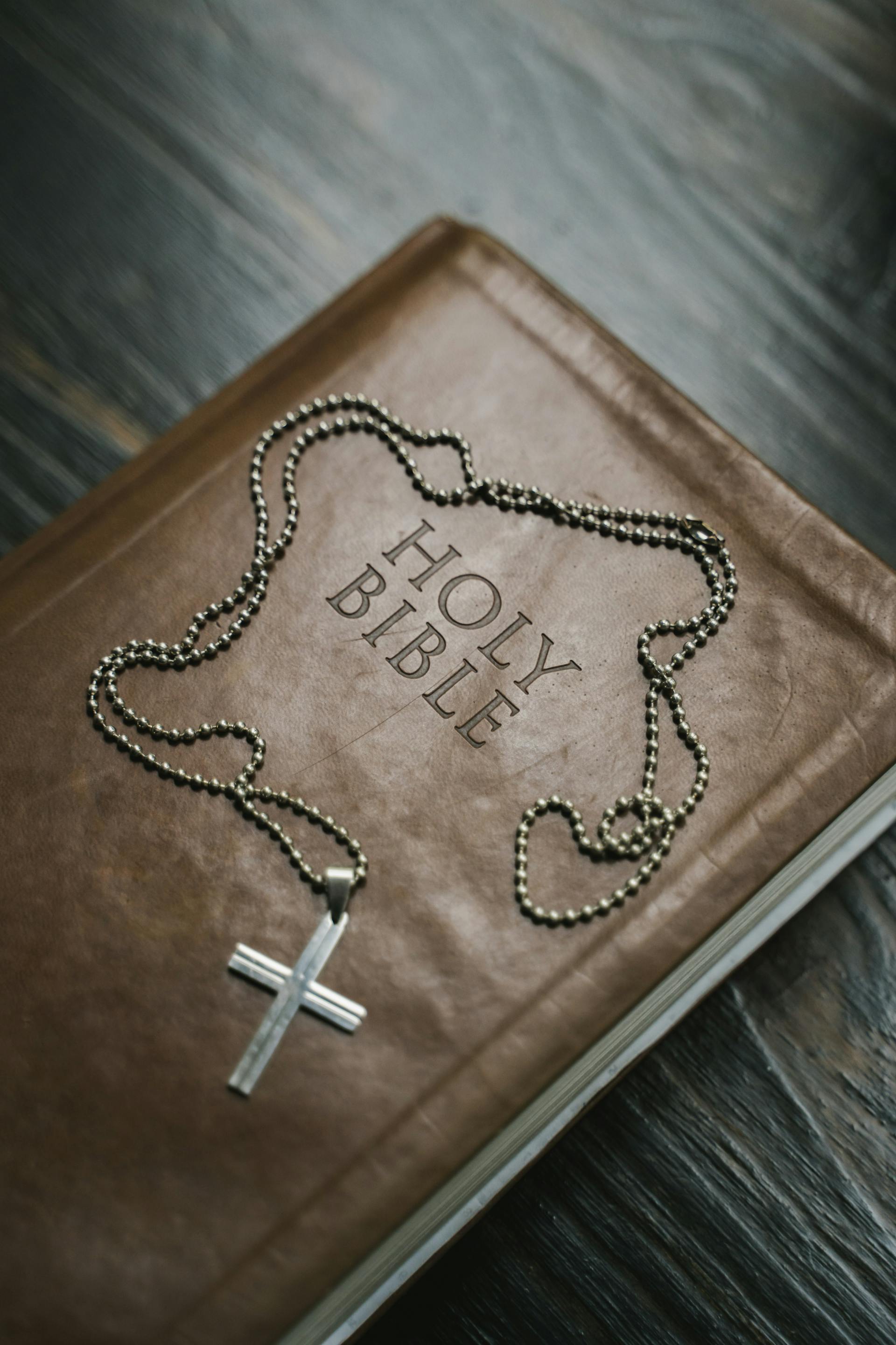 Eine Bibel und eine Silberkreuz-Halskette | Quelle: Pexels