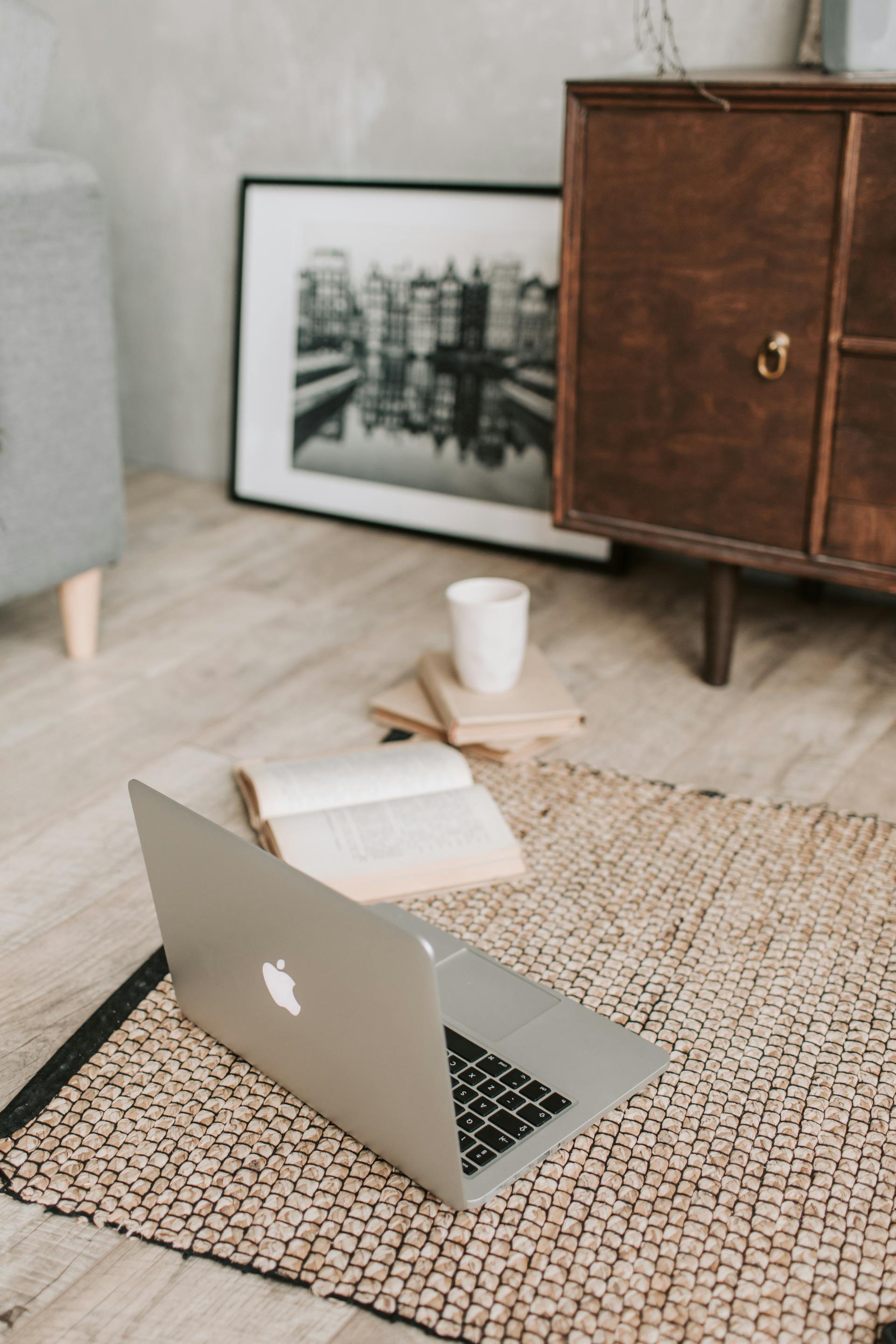 Ein Laptop und Bücher liegen auf einem Teppich | Quelle: Pexels
