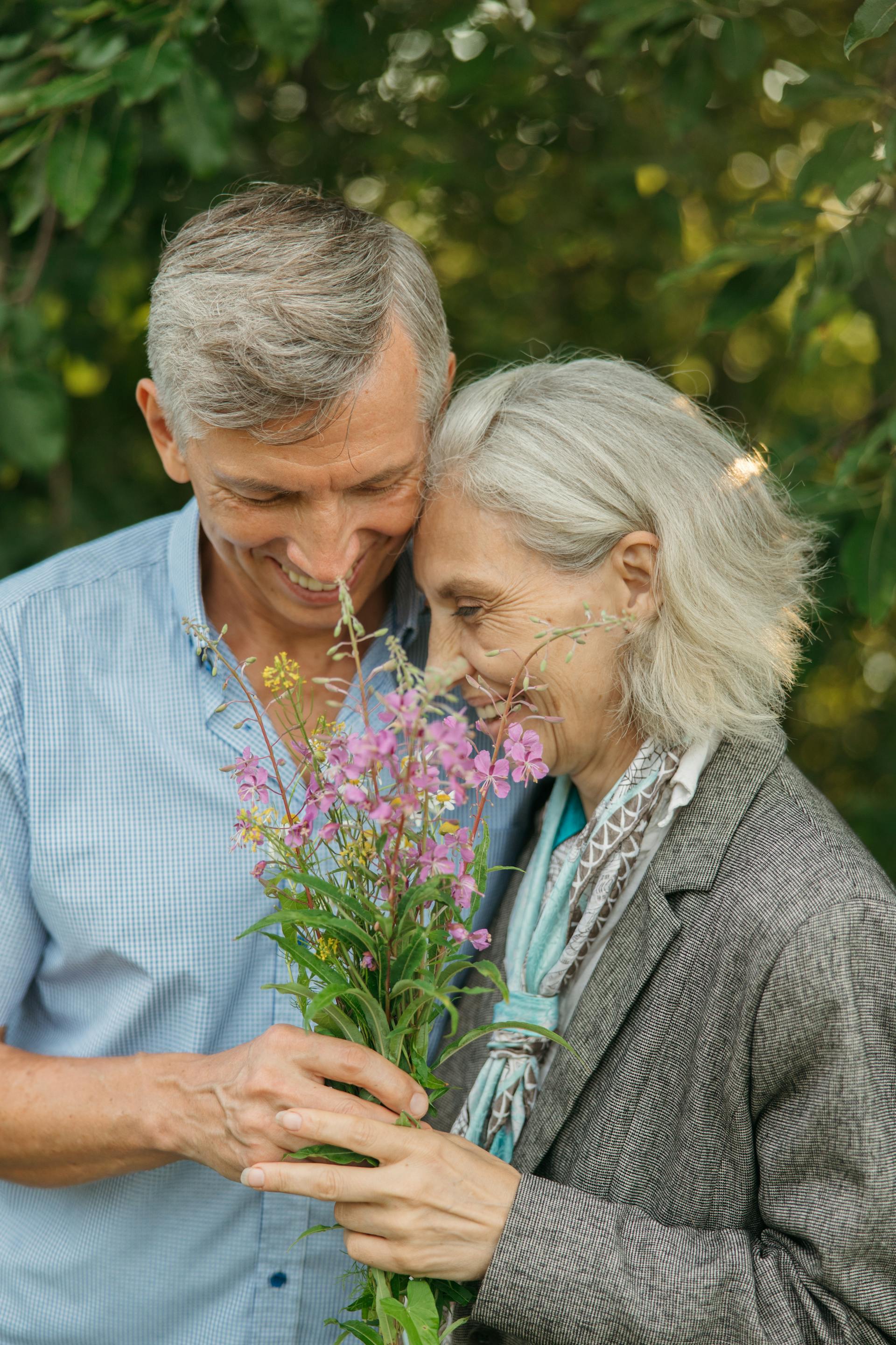 Eine Nahaufnahme eines älteren Paares, das Blumen hält | Quelle: Pexels