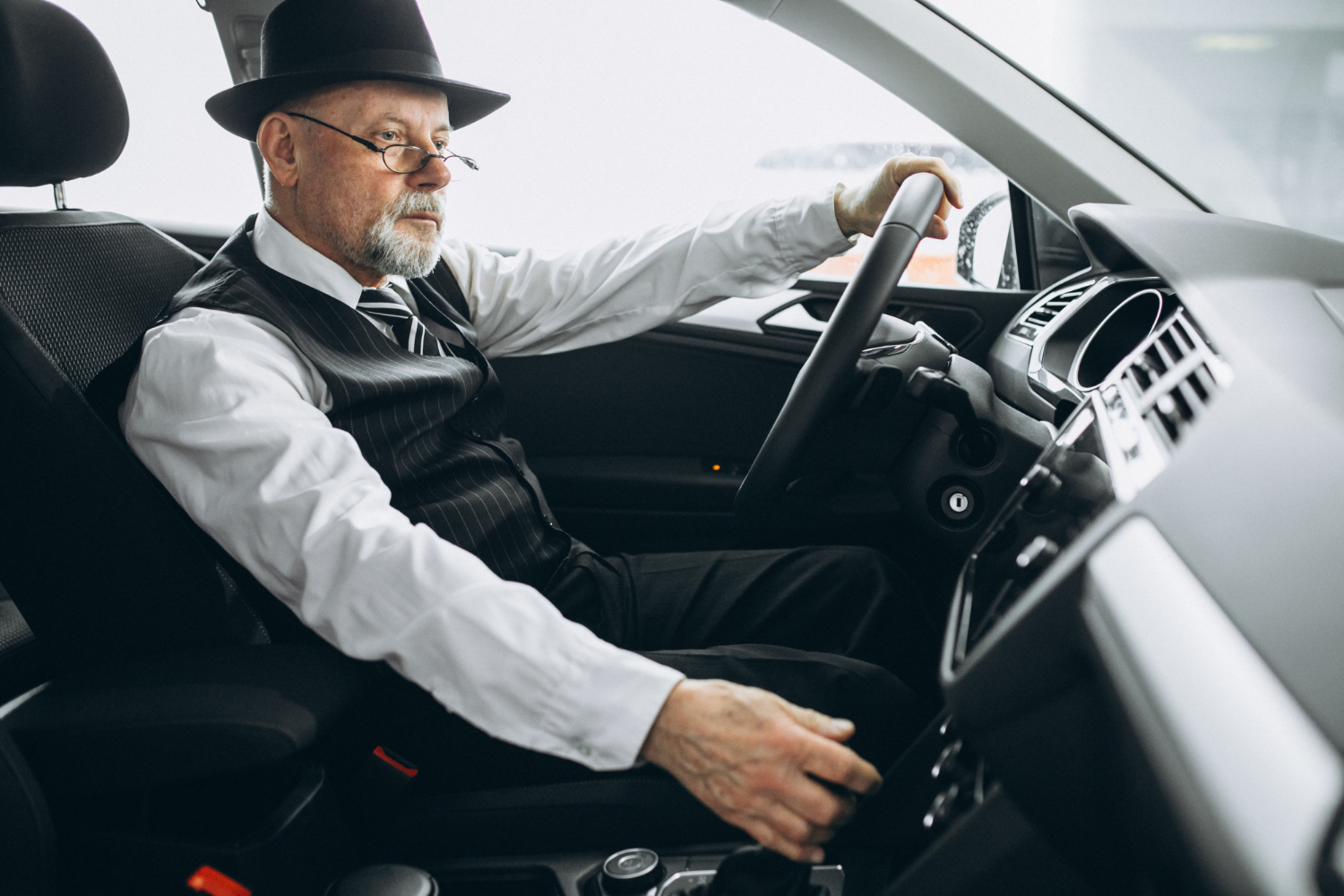 Ein wohlhabender älterer Mann am Steuer seines Autos | Quelle: Freepik