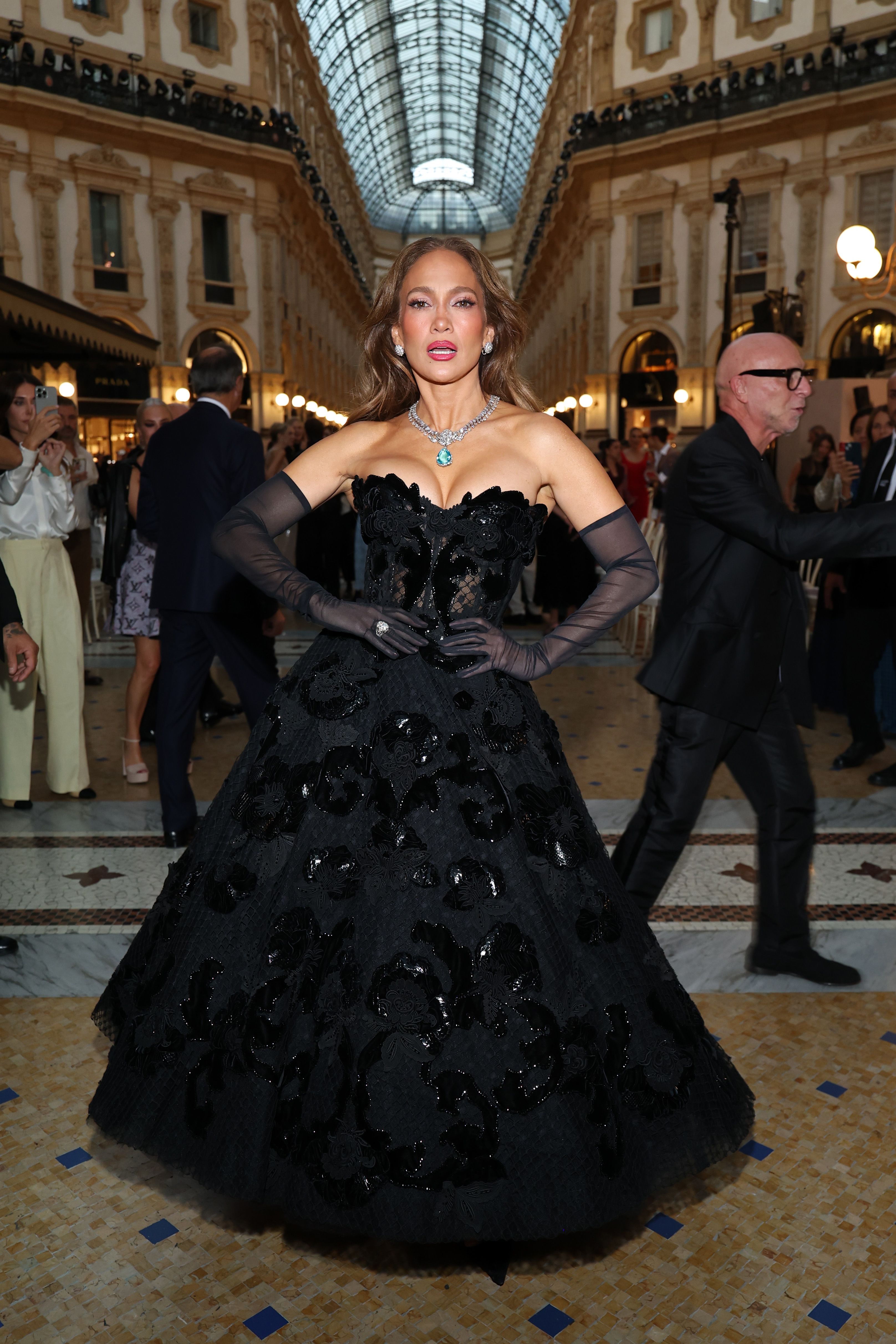 Lopez posiert mit den Händen in den Hüften und zeigt dabei die volle Silhouette und die floralen Details ihres schwarzen Ballkleids. | Quelle: Getty Images