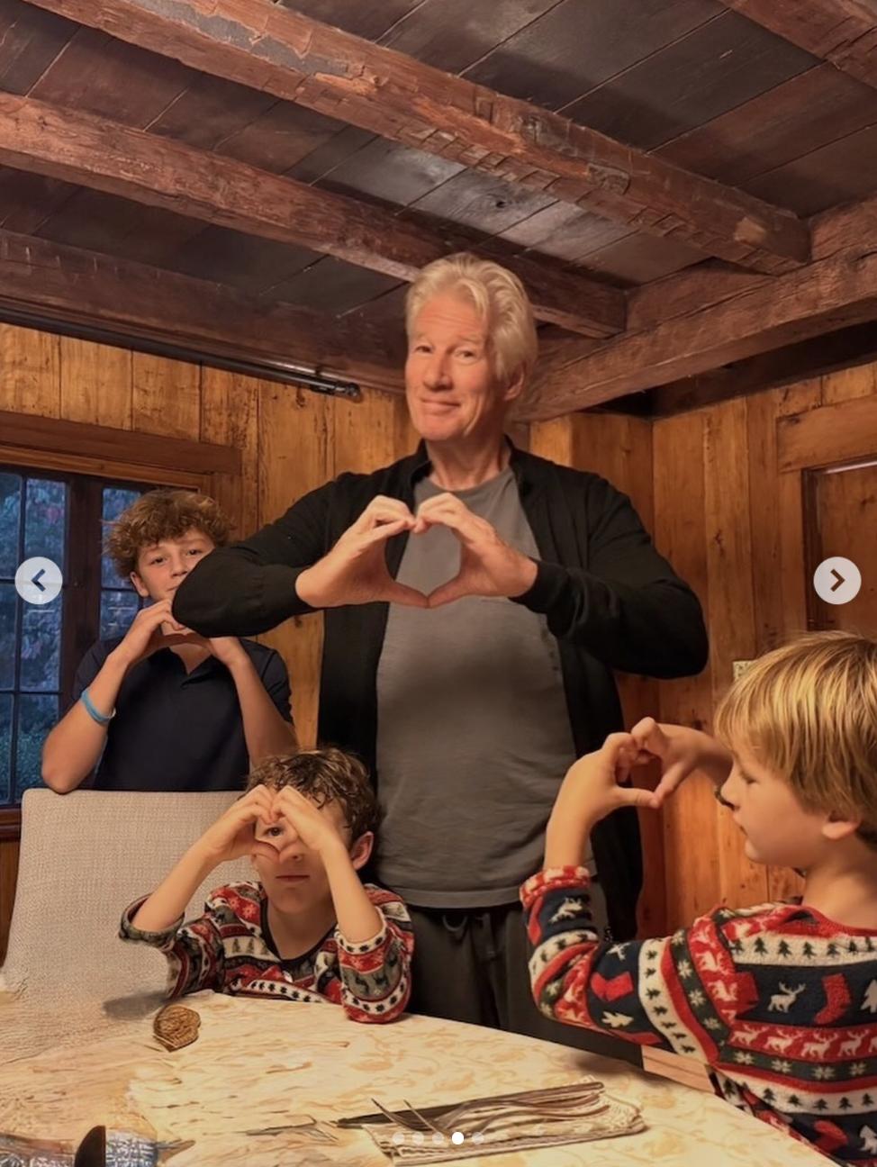 Richard Gere und seine Kinder sitzen gemeinsam am Esstisch im Haus der Familie in Spanien, wo freiliegende Holzbalken und getäfelte Wände eine warme, rustikale Atmosphäre schaffen. | Quelle: Instagram/alejandragere