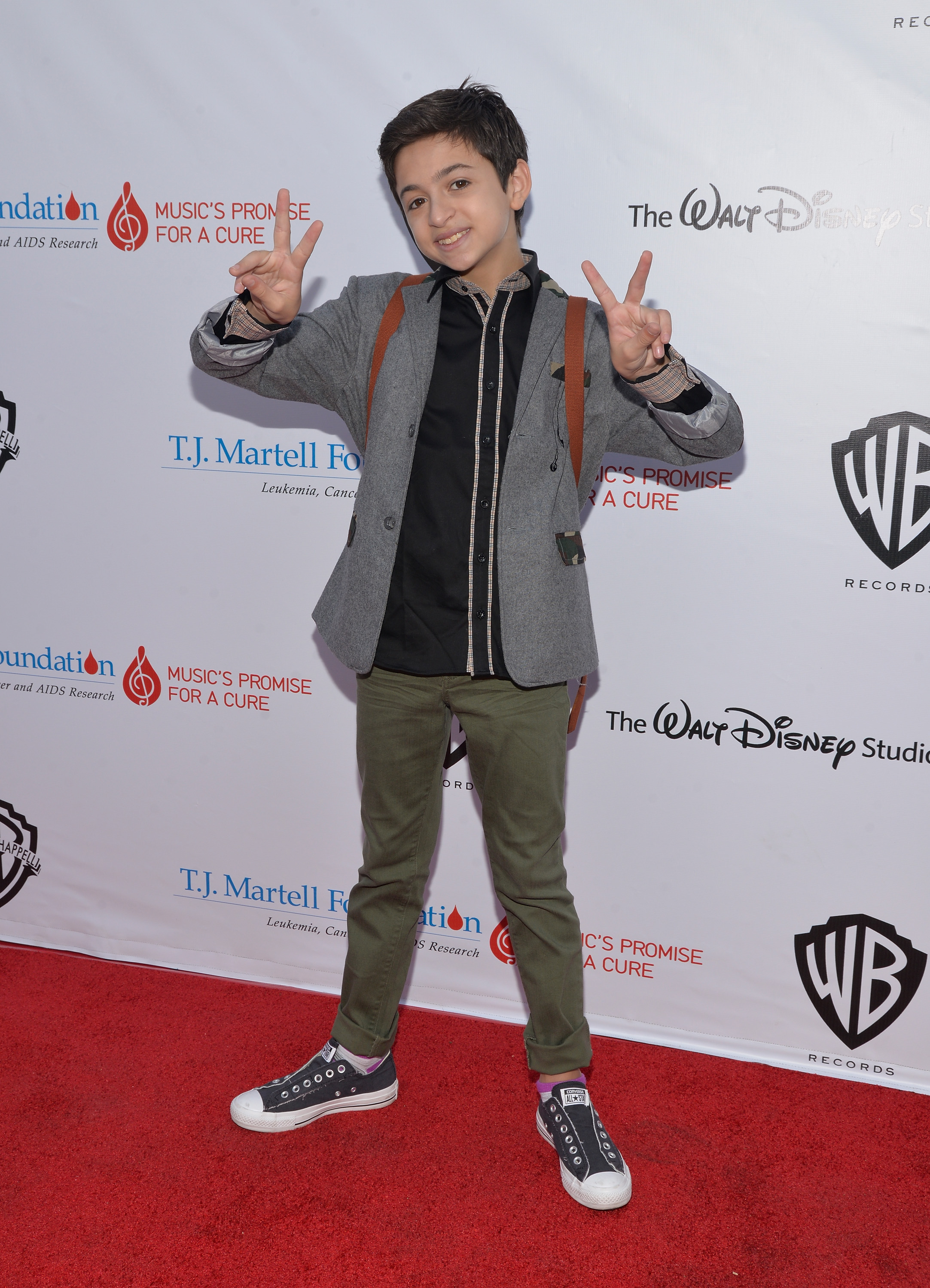 Auf dem roten Teppich beim 6. jährlichen „Family Day LA“-Event der T.J. Martell Foundation in Studio City, Kalifornien, zeigt sie Peace-Zeichen. Sie trägt einen grauen Blazer, ein schwarzes Shirt, olivgrüne Hosen und schwarze High-Top-Sneaker. | Quelle: Getty Images