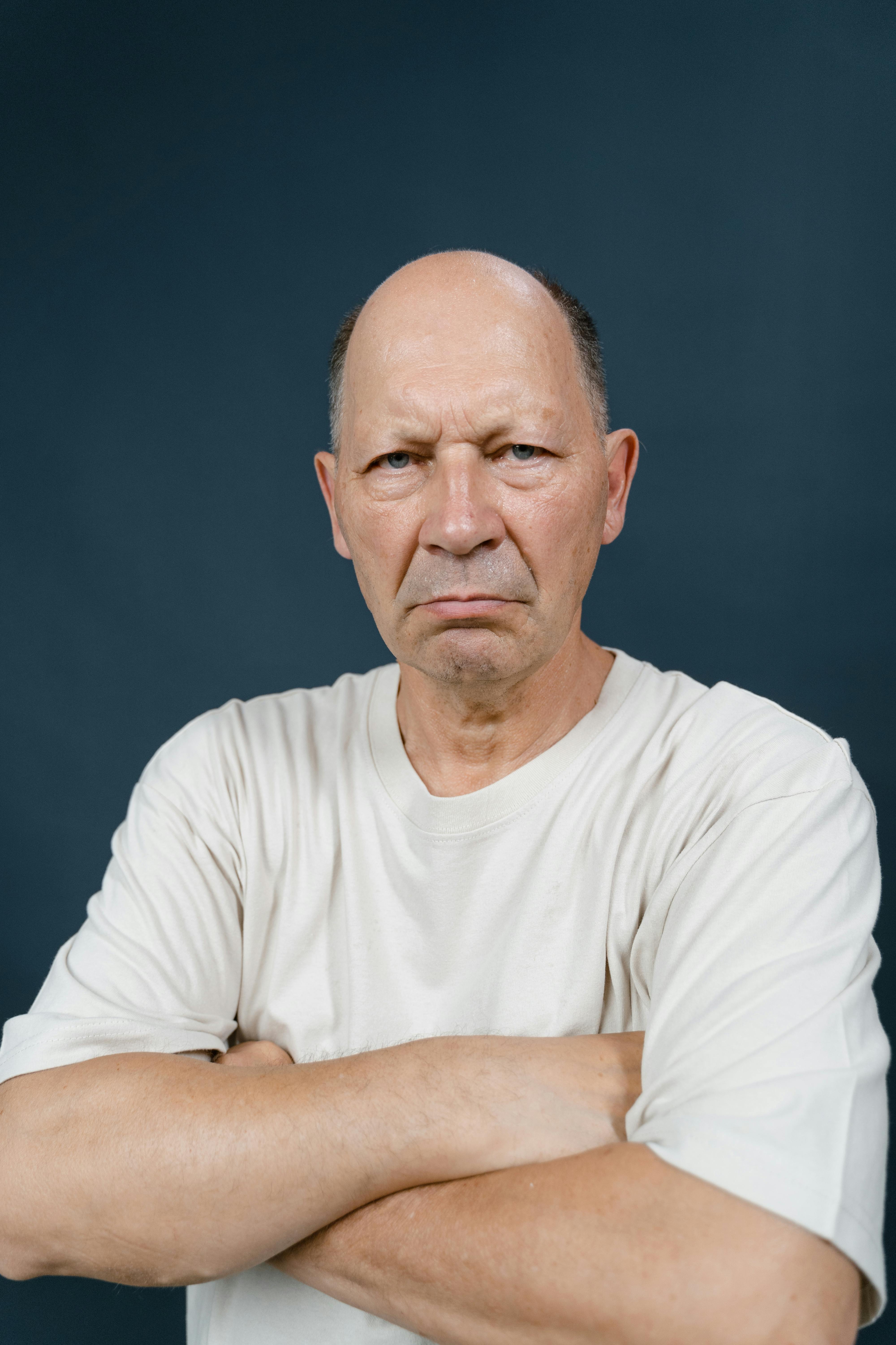 Ein wütender älterer Mann mit verschränkten Armen | Quelle: Pexels