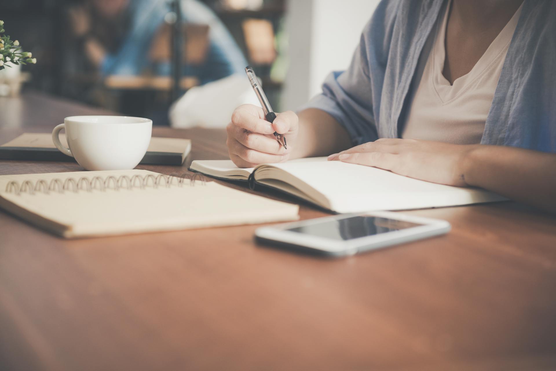 Eine Frau schreibt in ein Notizbuch | Sourrce: Pexels