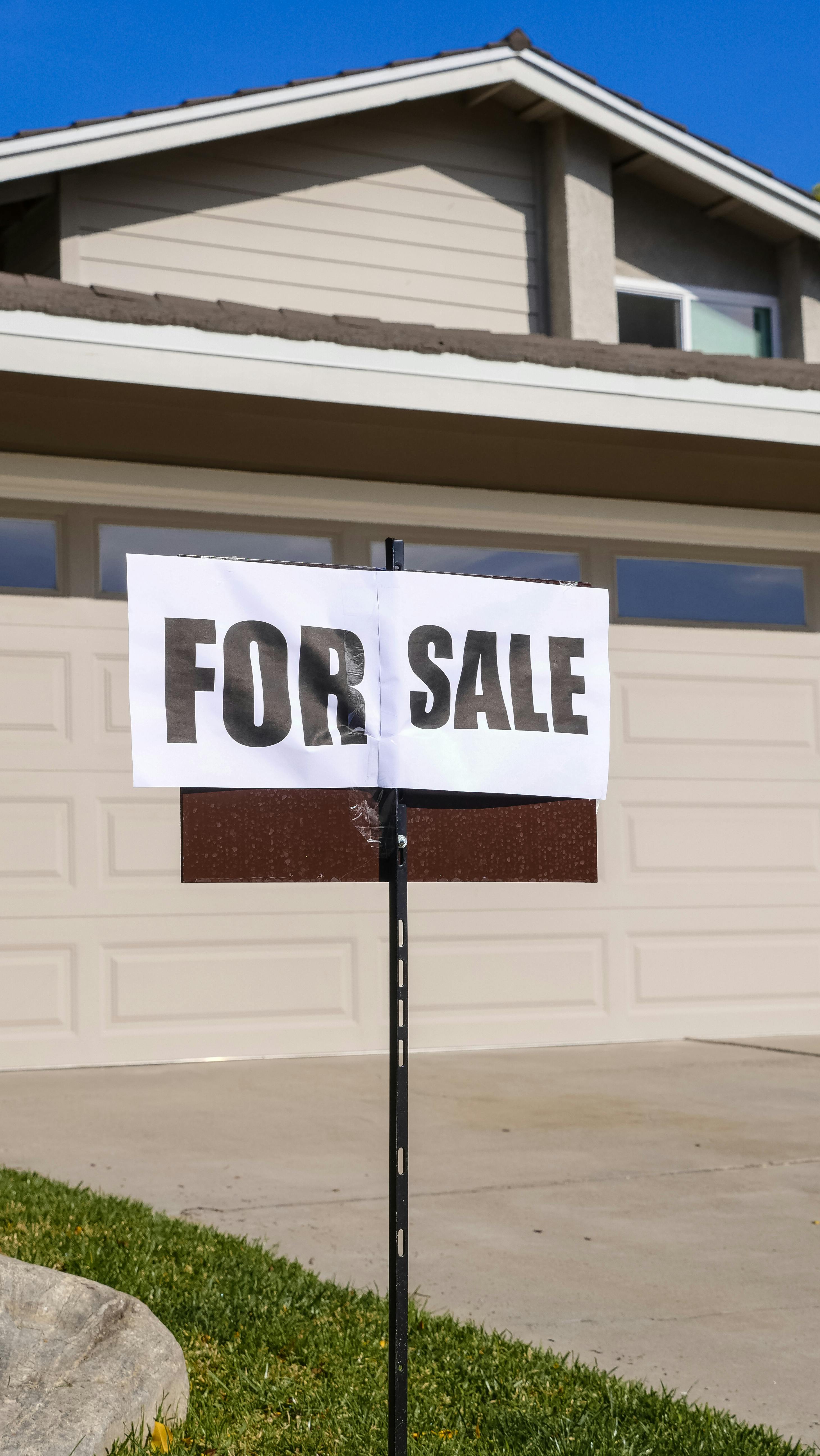 Ein "Zu verkaufen"-Schild vor einem Haus | Quelle: Pexels