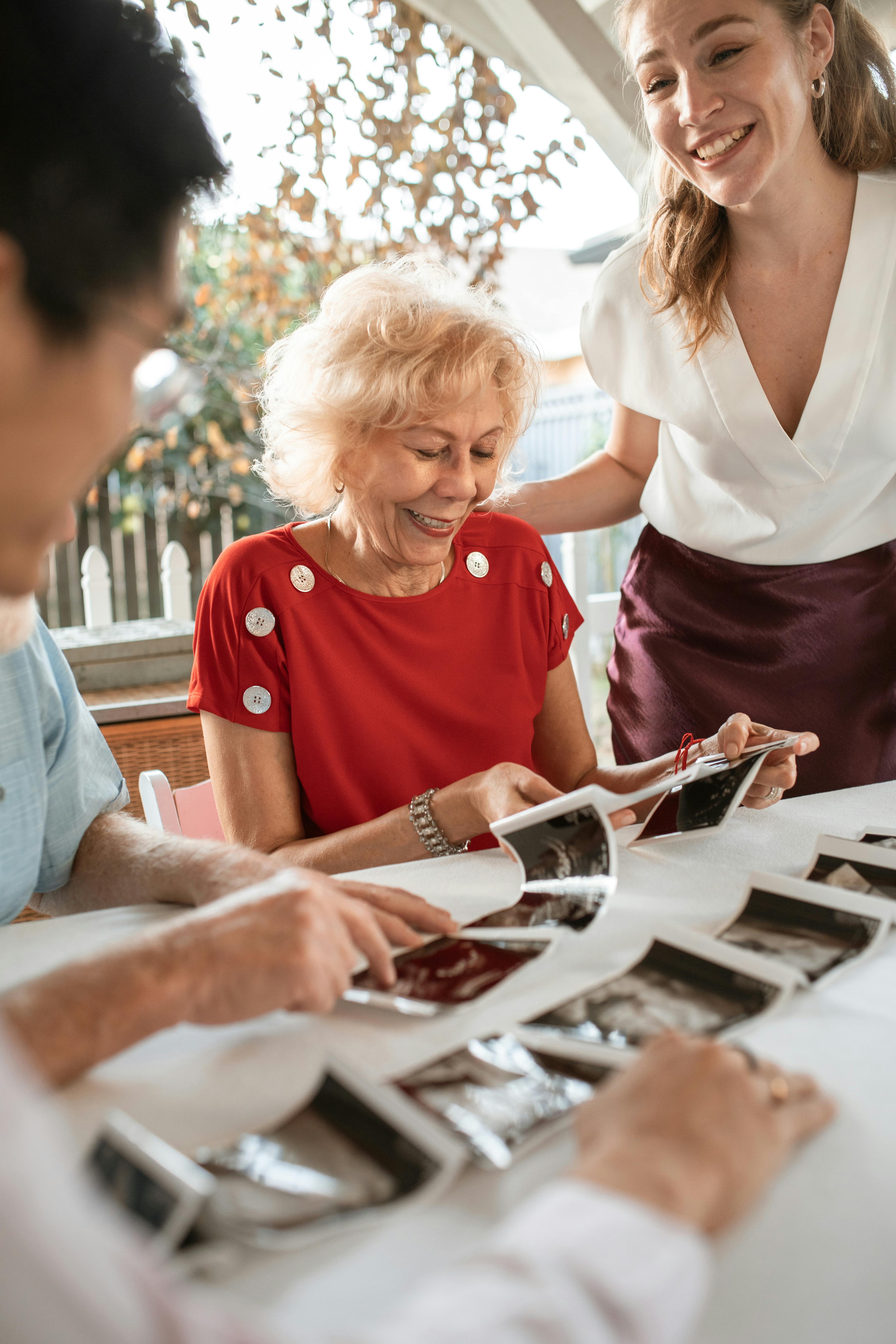 Familie beim gemeinsamen Betrachten von Fotos | Quelle: Pexels