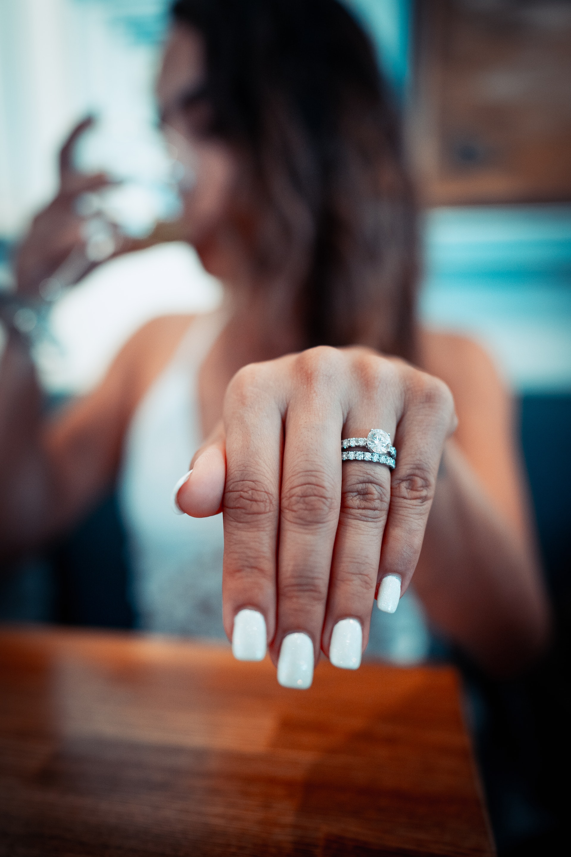 Eine Frau mit weißem Nagellack, die ihren Ring zur Schau stellt | Quelle: Pexels