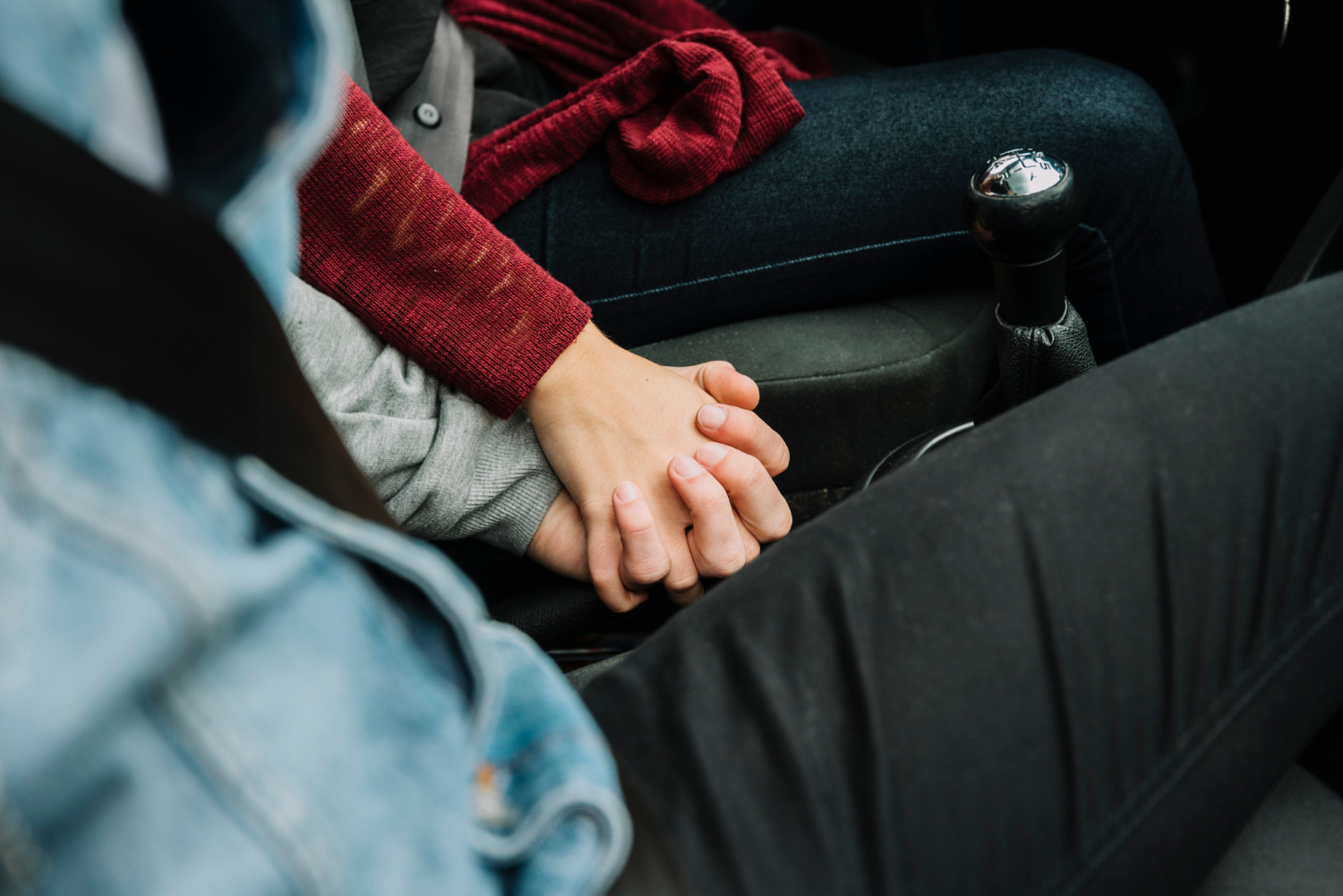 Ein Paar sitzt im Auto und hält sich an den Händen | Quelle: Freepik