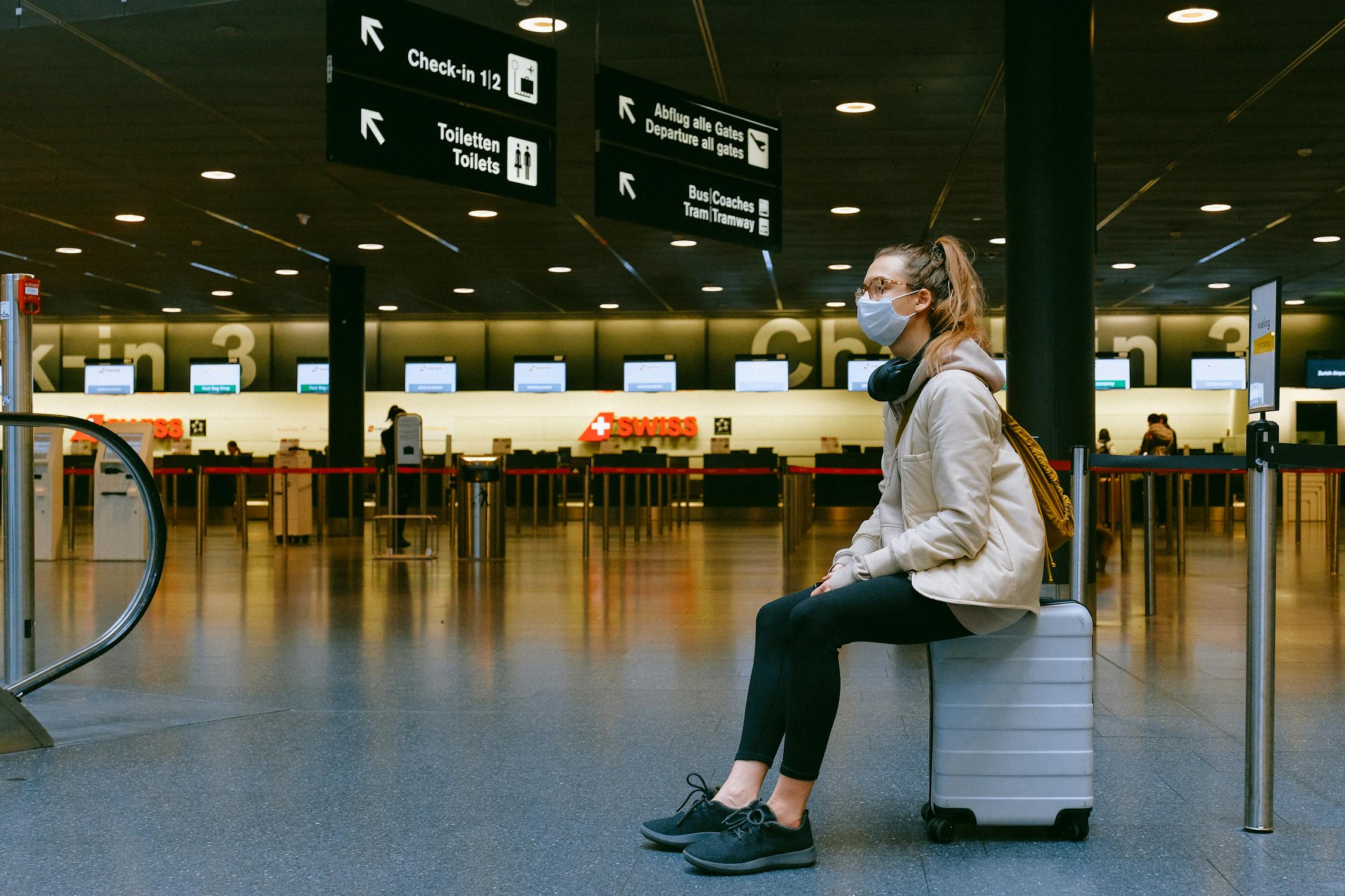 Eine Frau, die auf einem Koffer sitzt | Quelle: Pexels