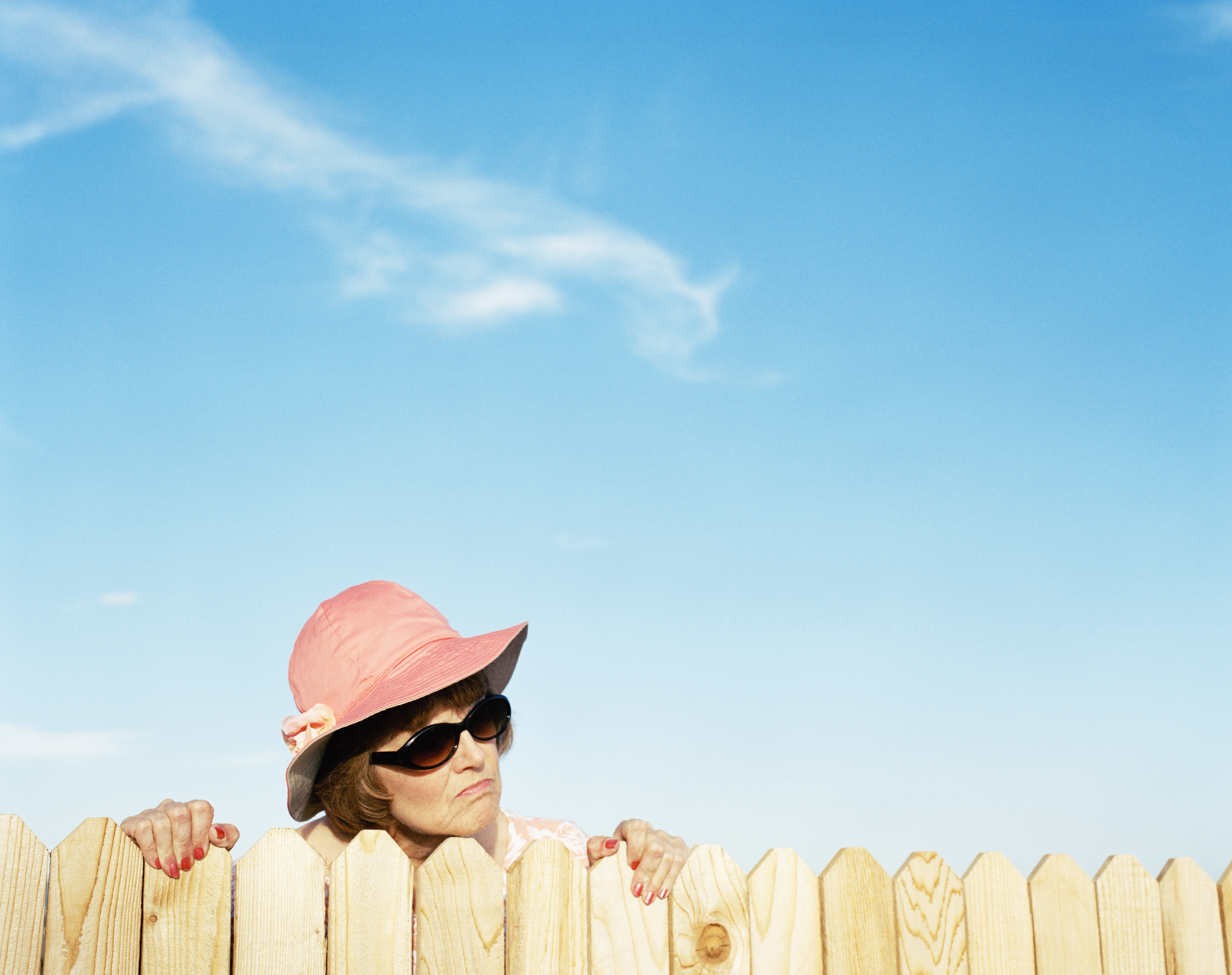Eine Frau schaut über den Zaun | Quelle: Getty Images
