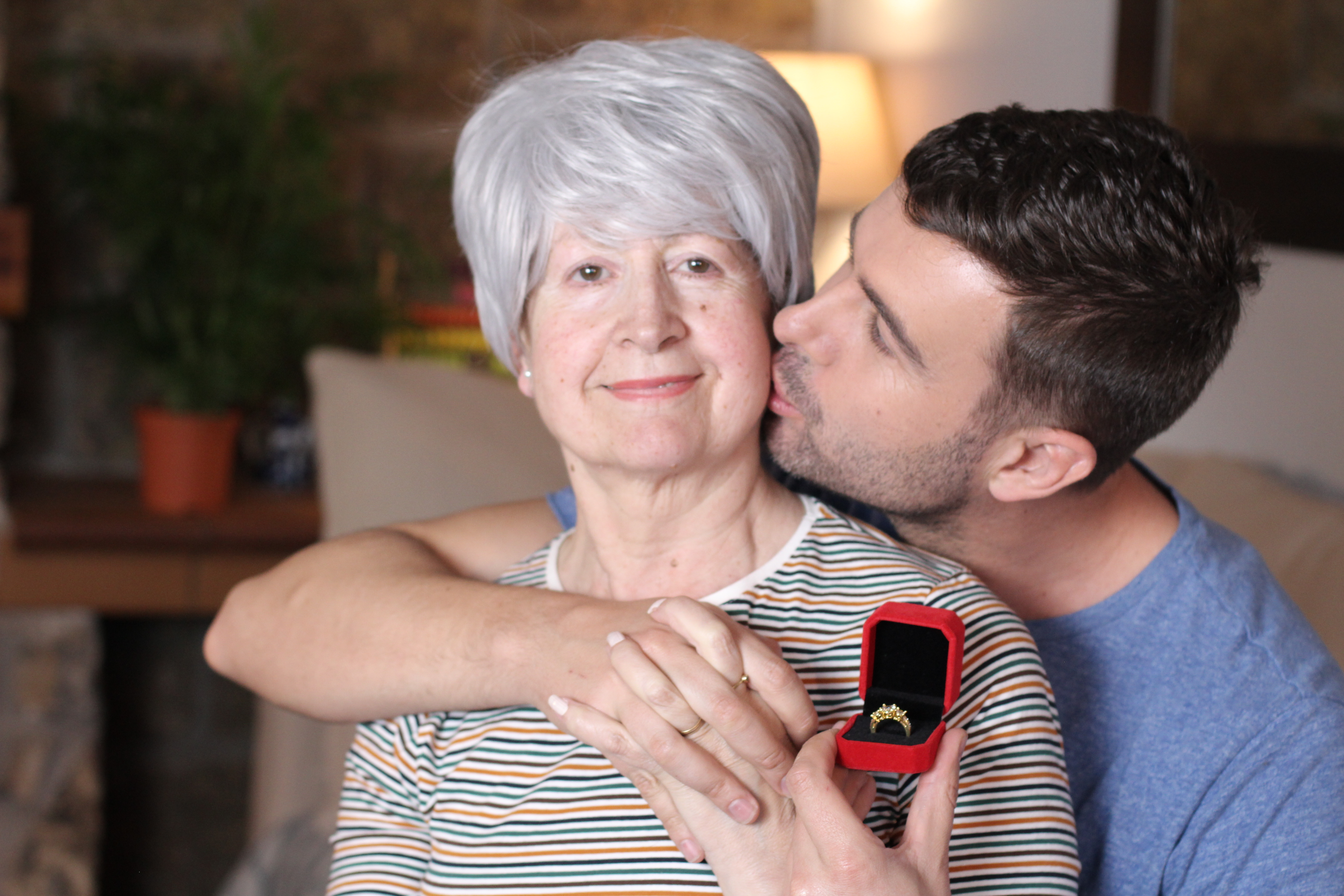 Ein junger Mann küsst eine ältere Frau auf die Wange | Quelle: Shutterstock