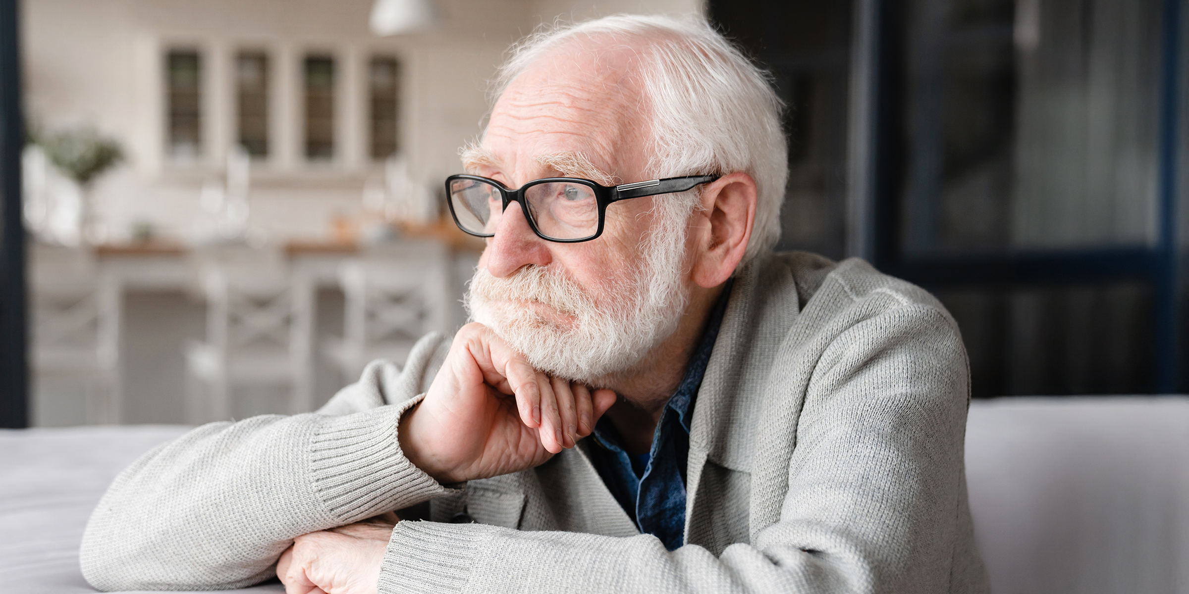 Ein trauriger alter Mann sitzt auf einer Couch | Quelle: Shutterstock