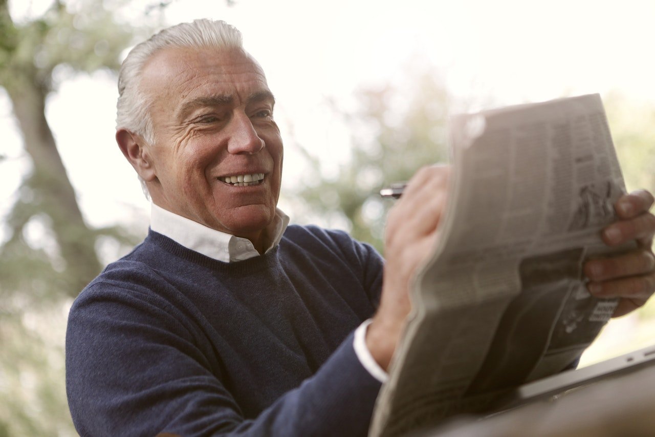 Älterer Mann liest eine Zeitung. | Quelle: Pexels/Andrea Piacquadio