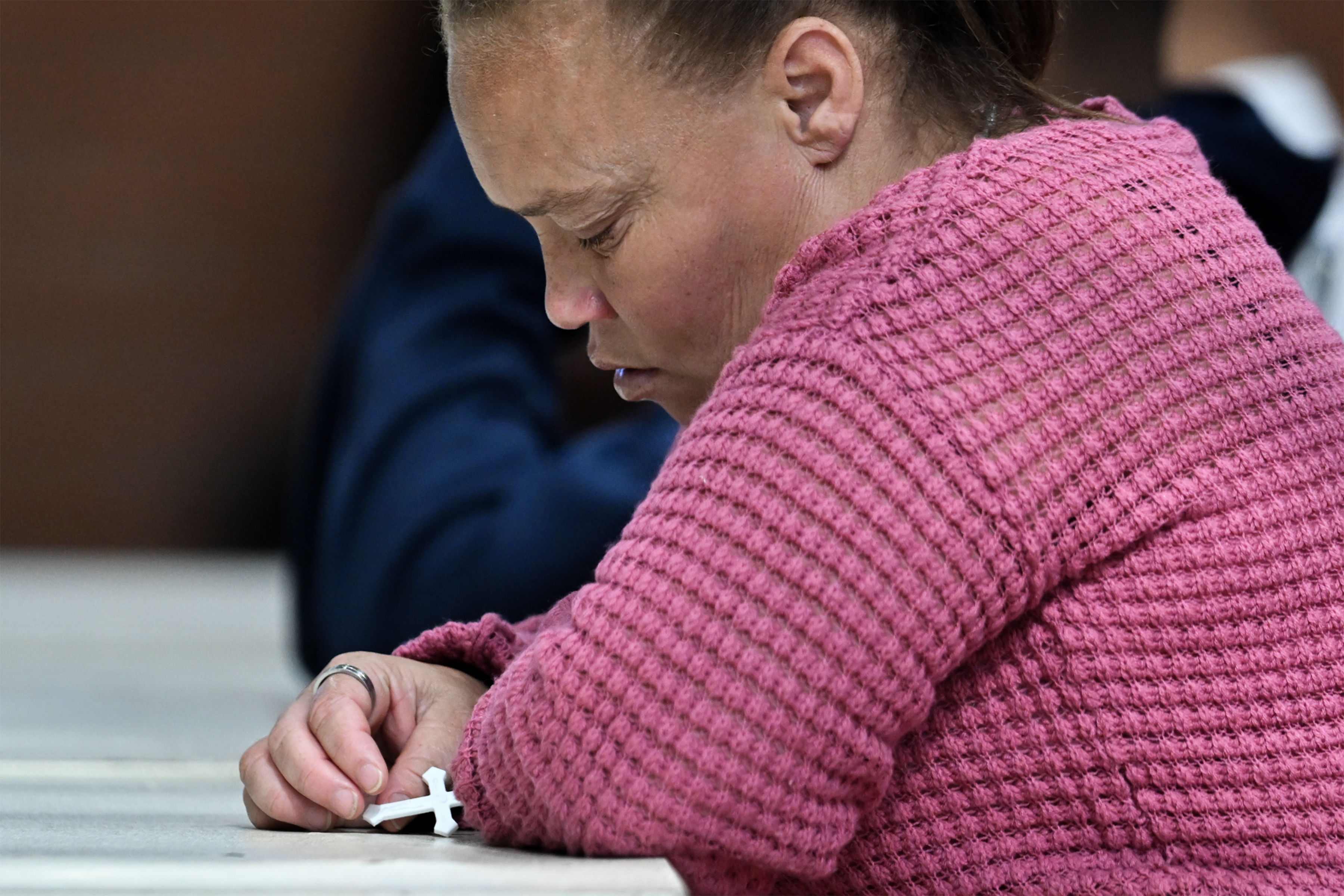Racquel Smith hält ein Kreuz während des Prozesses im Fall der verschwundenen Joshlin Smith am 7. Tag im White City Multipurpose Centre am 11. März 2025 in Saldanha Bay, Südafrika | Quelle: Getty Images