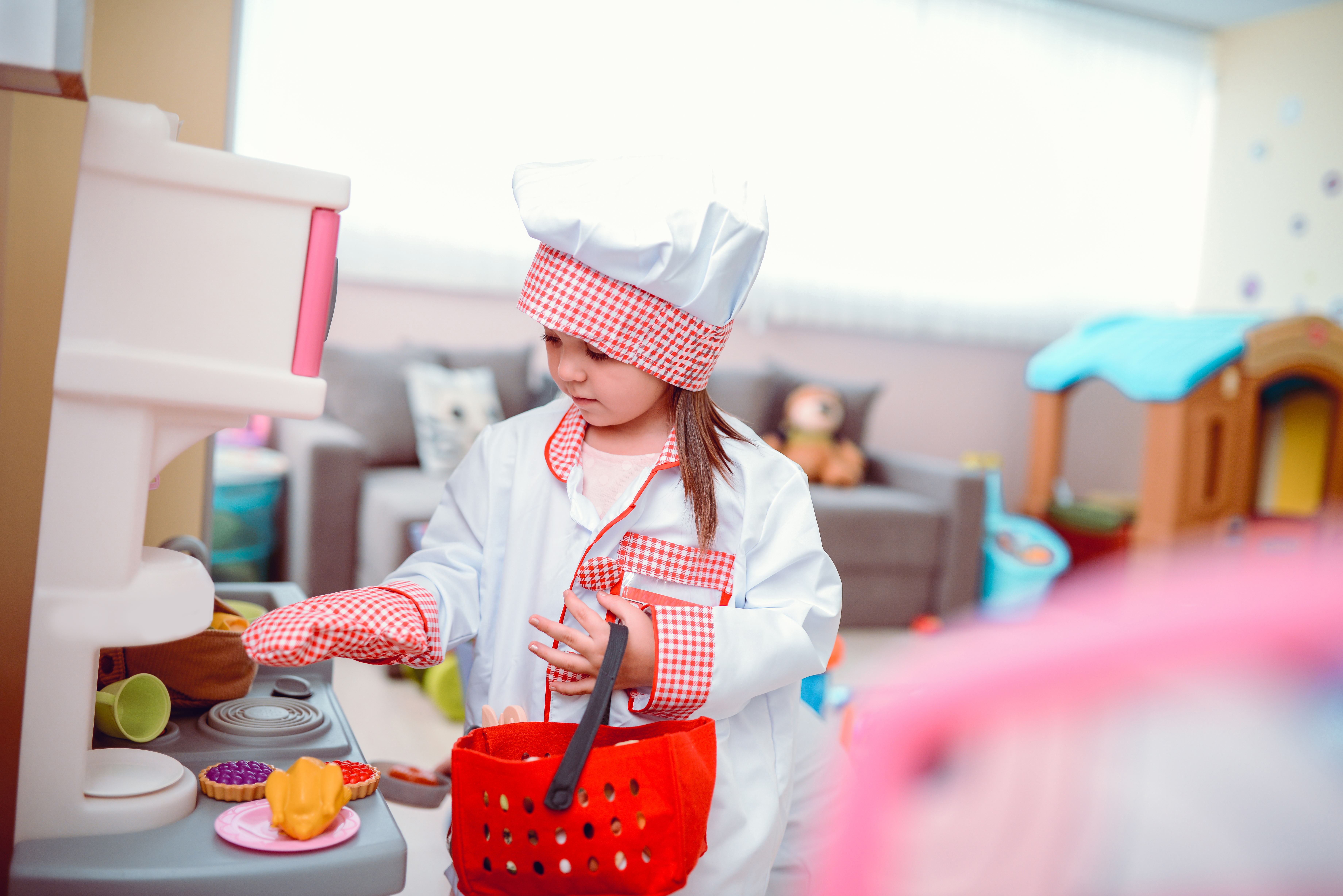 Kleines Mädchen spielt Koch in einem Vorschulklassenzimmer | Quelle: Getty Images