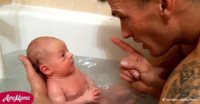 Der Vater badet das neugeborene Baby zum ersten Mal. Es ist so niedlich