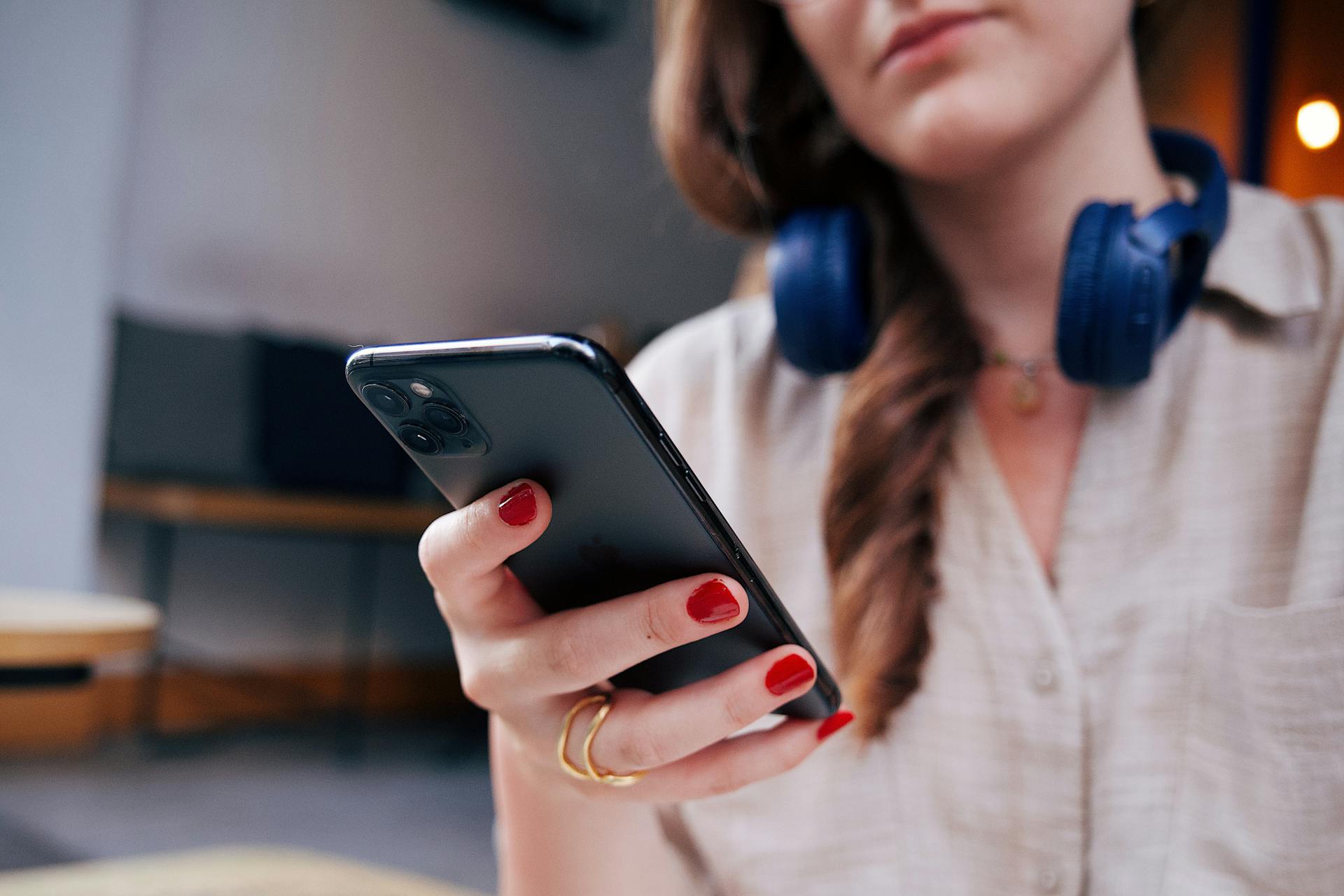 Eine lächelnde Frau, die auf ihr Telefon schaut | Quelle: Pexels