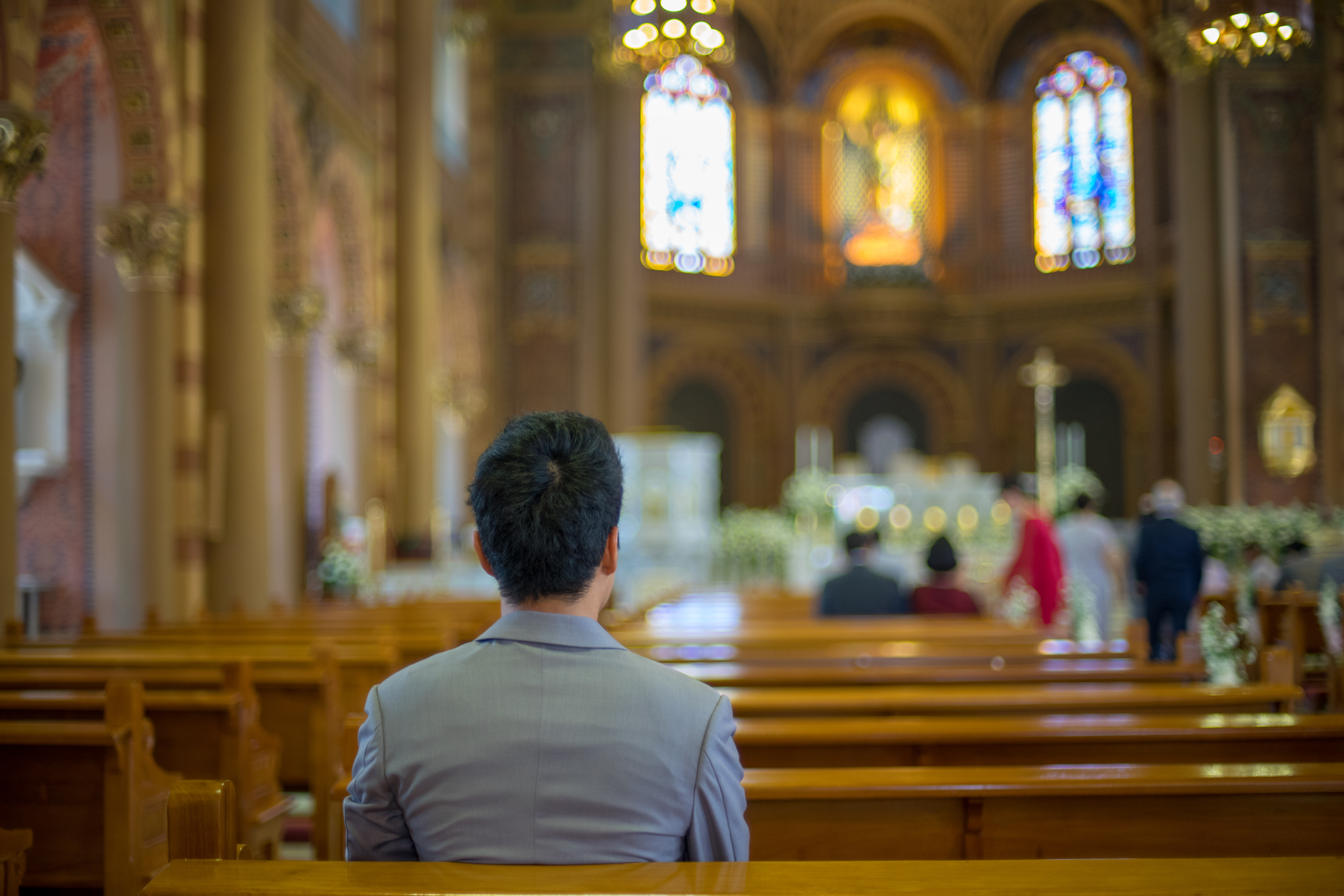 Ein junger Mann sitzt in der Kirche | Quelle: Shutterstock