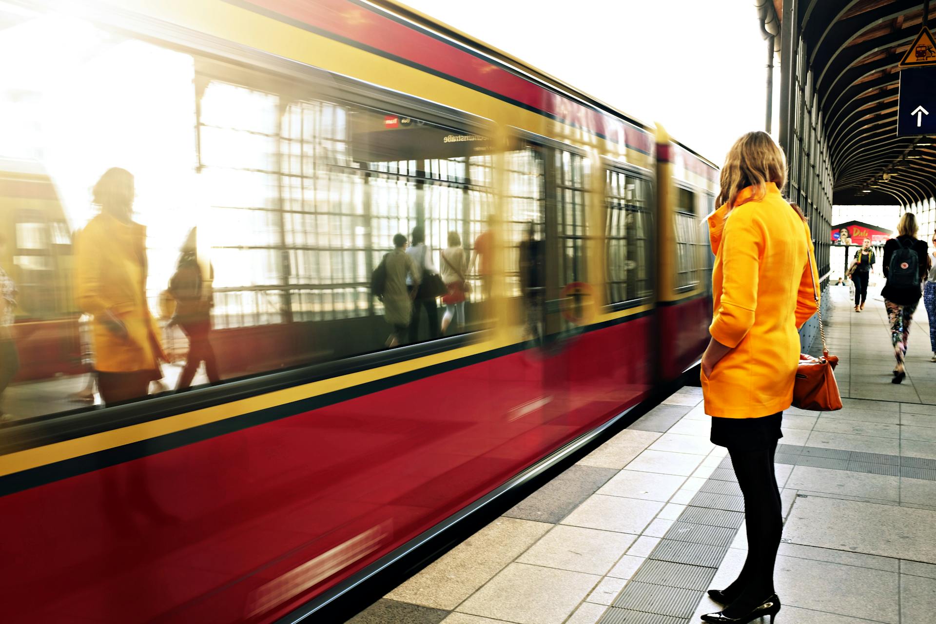 Eine Frau steht neben einem roten Zug | Quelle: Pexels