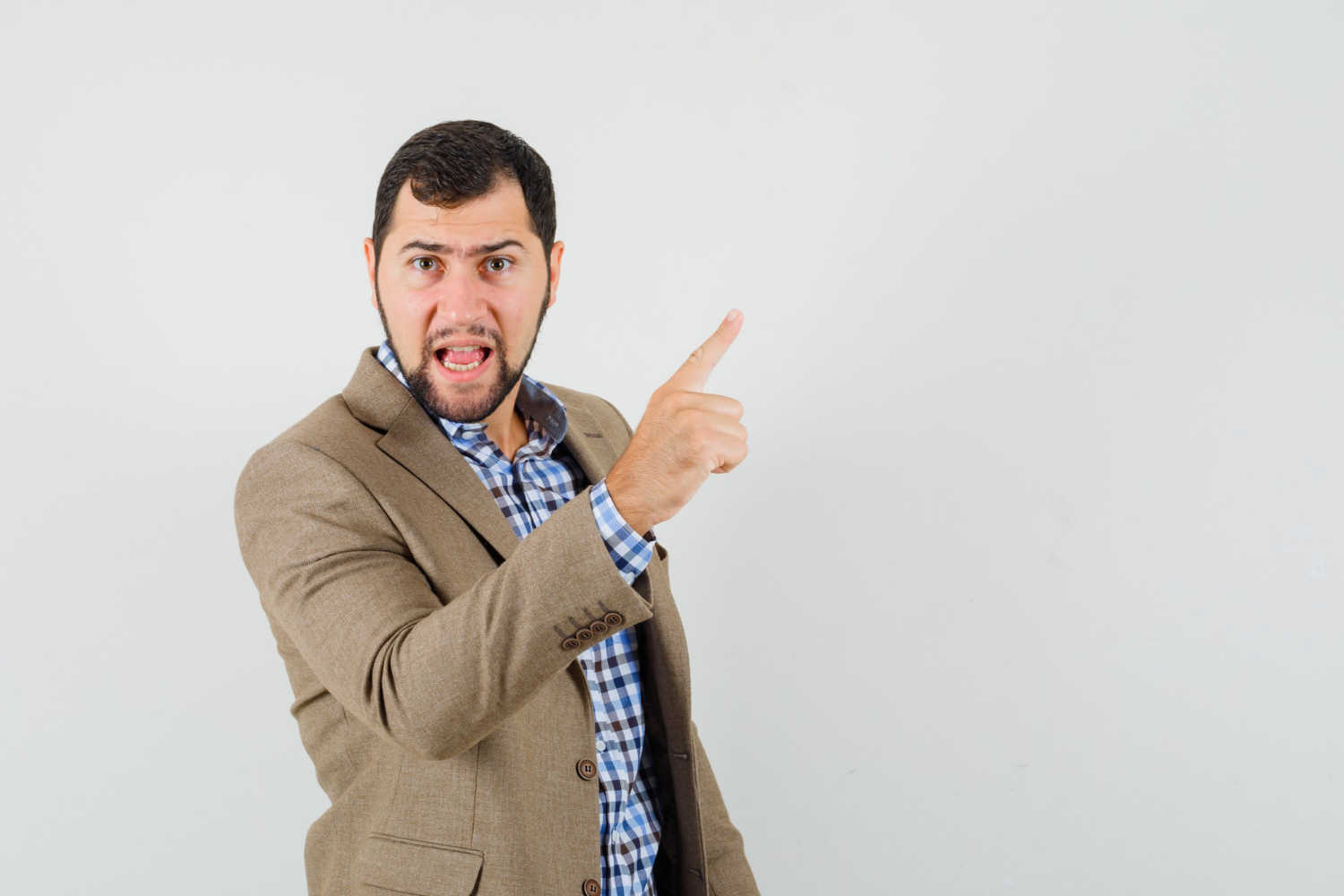 Wściekły mężczyzna wskazujący palcem | Źródło: Freepik