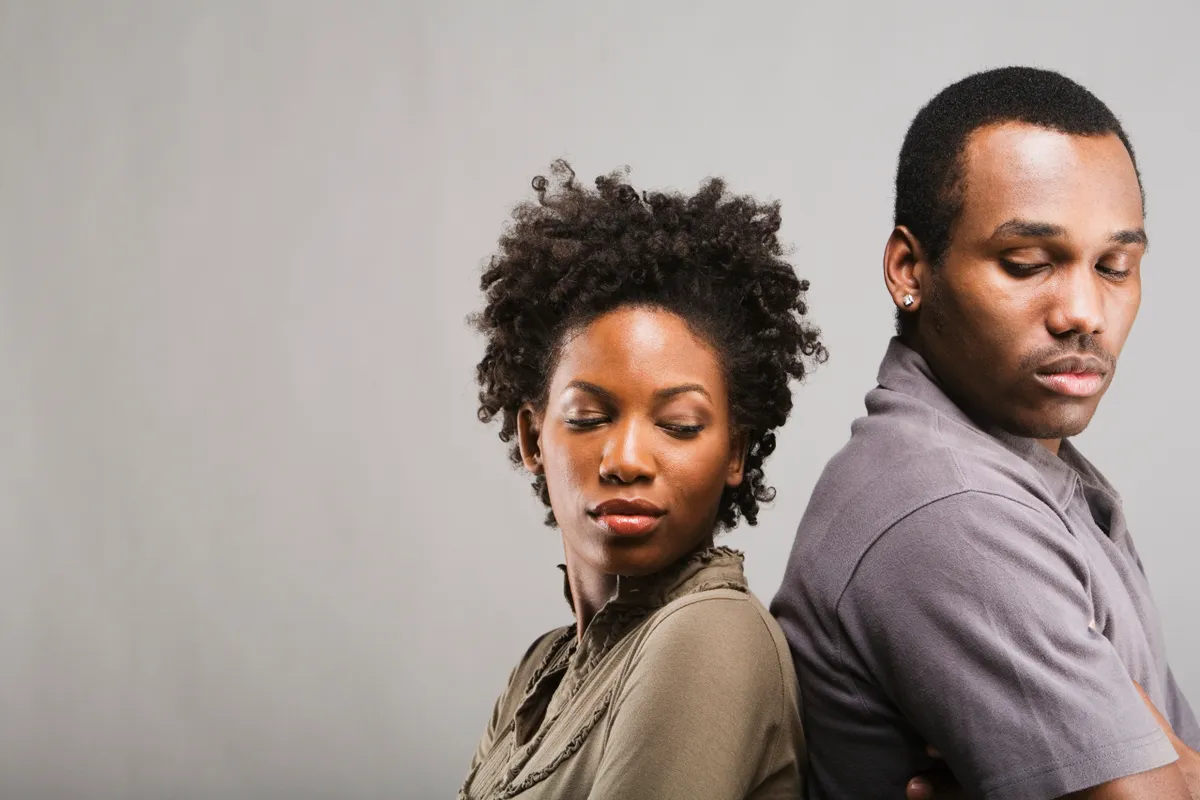 Ein wütendes afroamerikanisches Paar, das Rücken an Rücken steht | Quelle: Getty Images