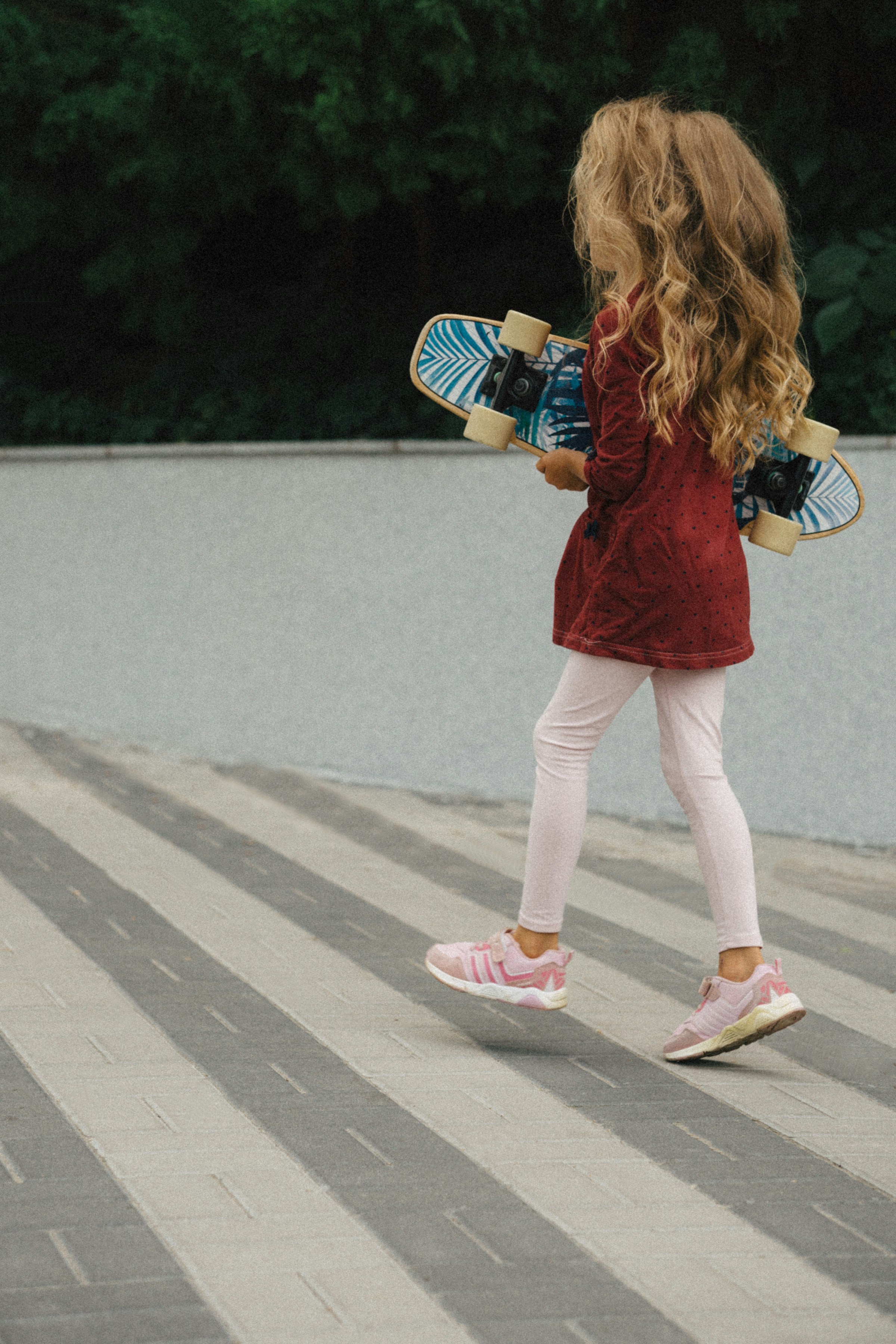 Ein kleines Mädchen hält ein Skateboard | Quelle: Unsplash