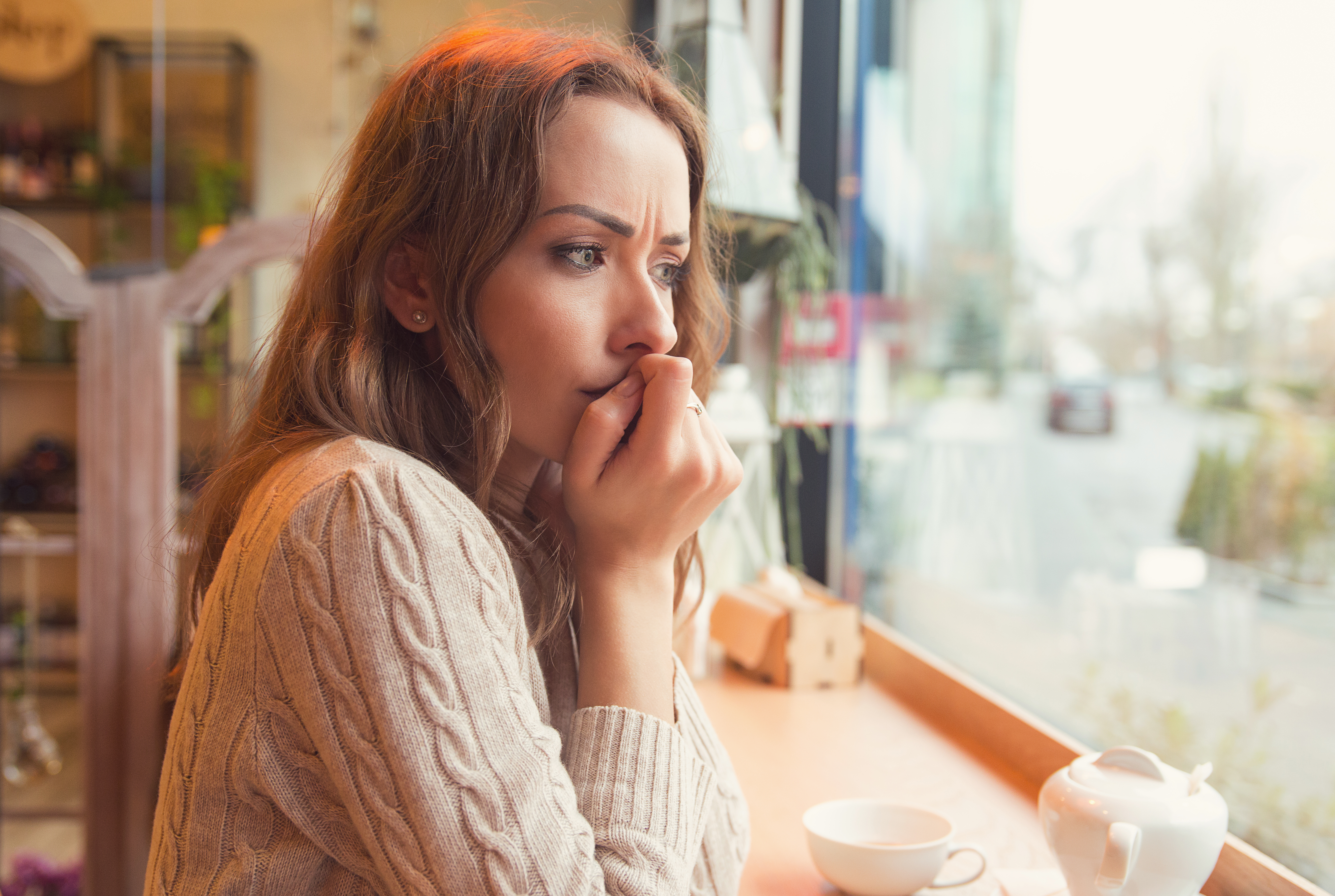 Eine nervöse junge Frau in einem Café | Quelle: Shutterstock