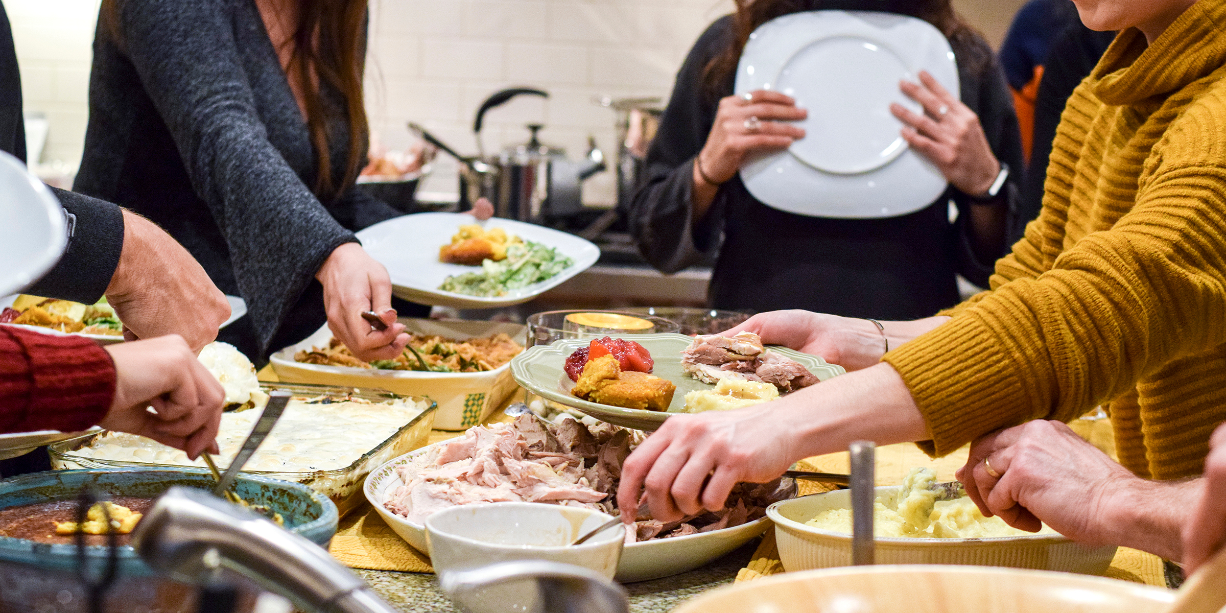 Menschen stehen um Essen herum | Quelle: Shutterstock