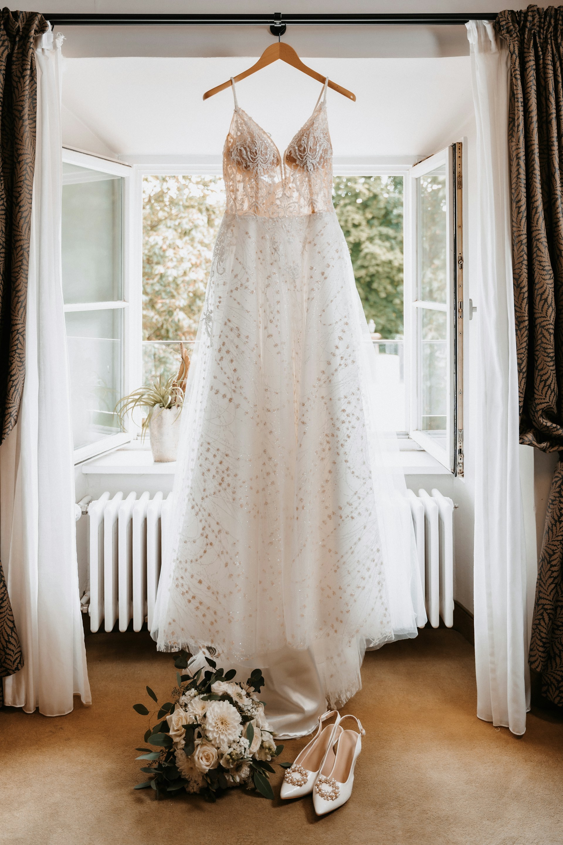 Ein Brautkleid und Accessoires in der Nähe eines Fensters | Quelle: Unsplash