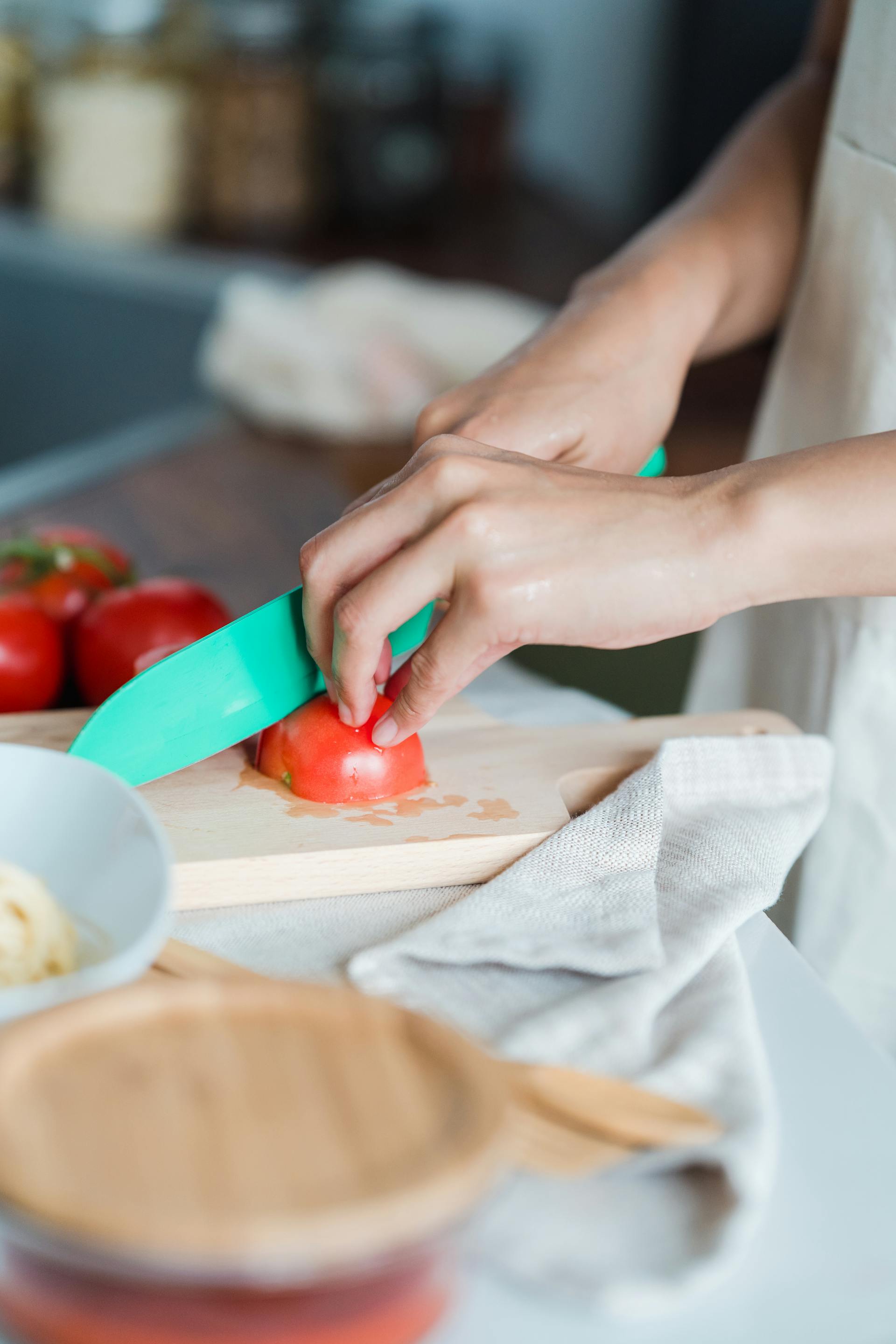 Eine Person, die Tomaten schneidet | Quelle: Pexels