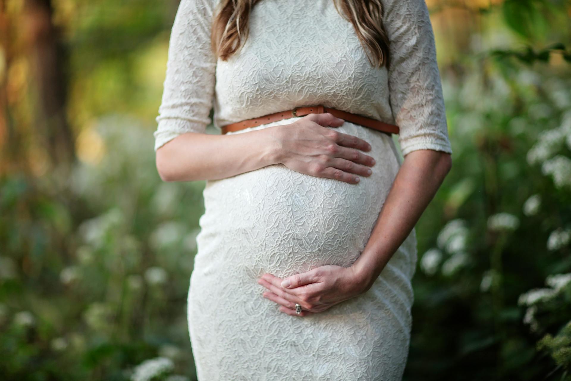 Eine schwangere Frau, die ihren Babybauch umfängt | Quelle: Pexels