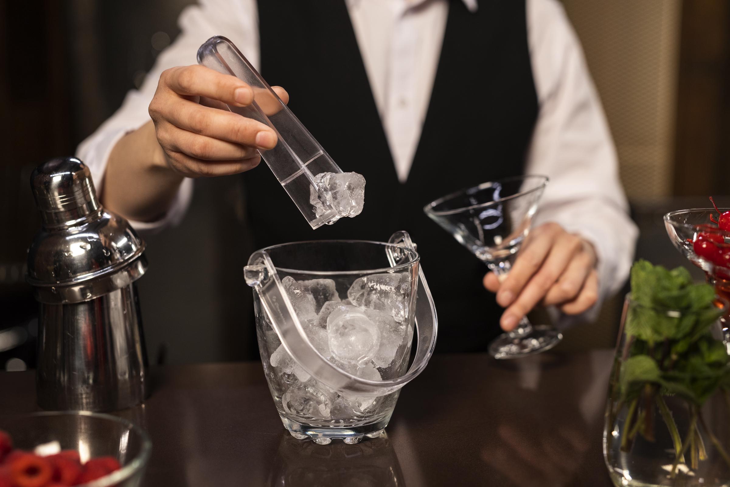 Ein Restaurantangestellter bereitet einen Drink on the rocks zu | Quelle: Freepik