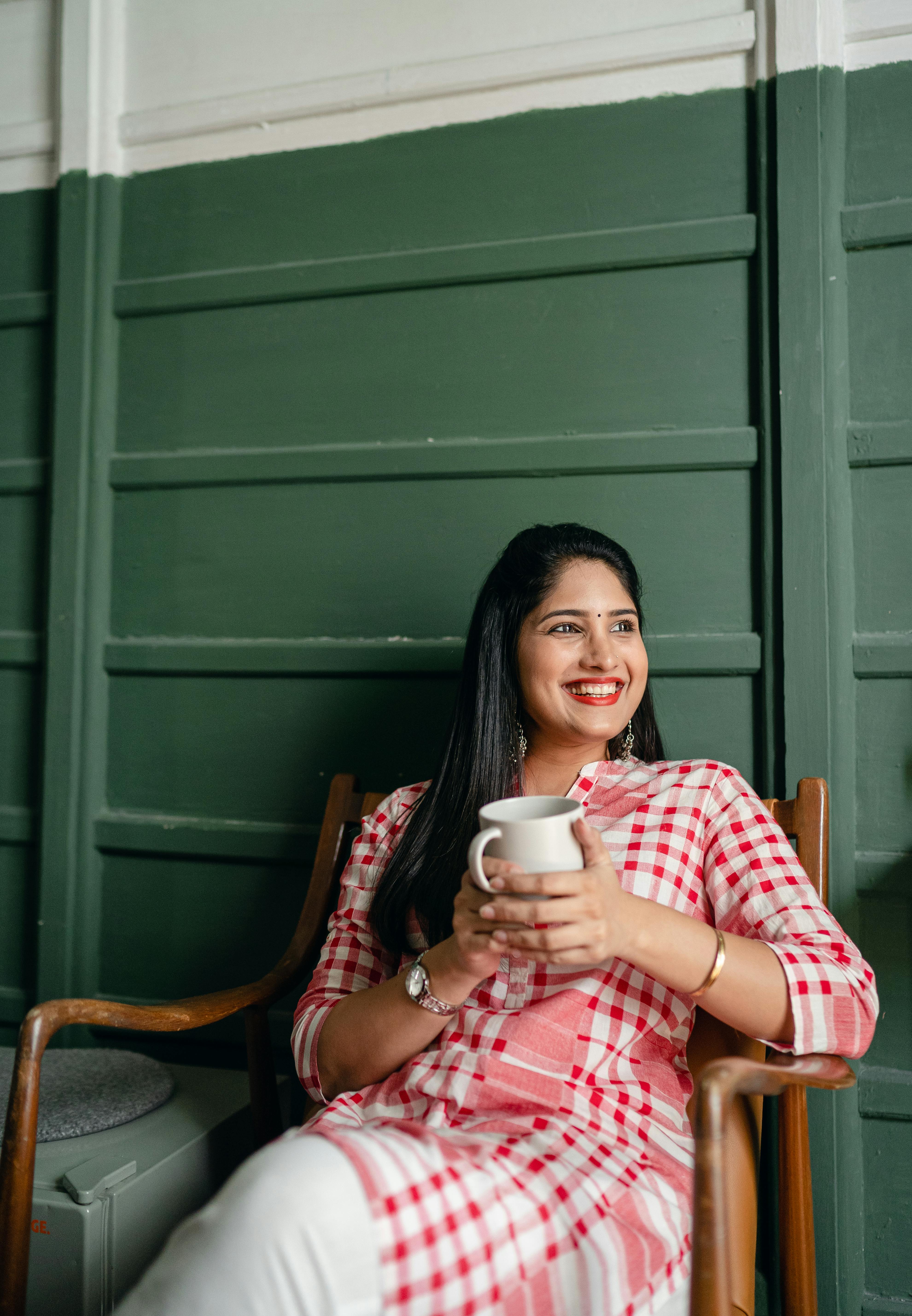 Eine glückliche Frau, die eine Tasse hält | Quelle: Pexels