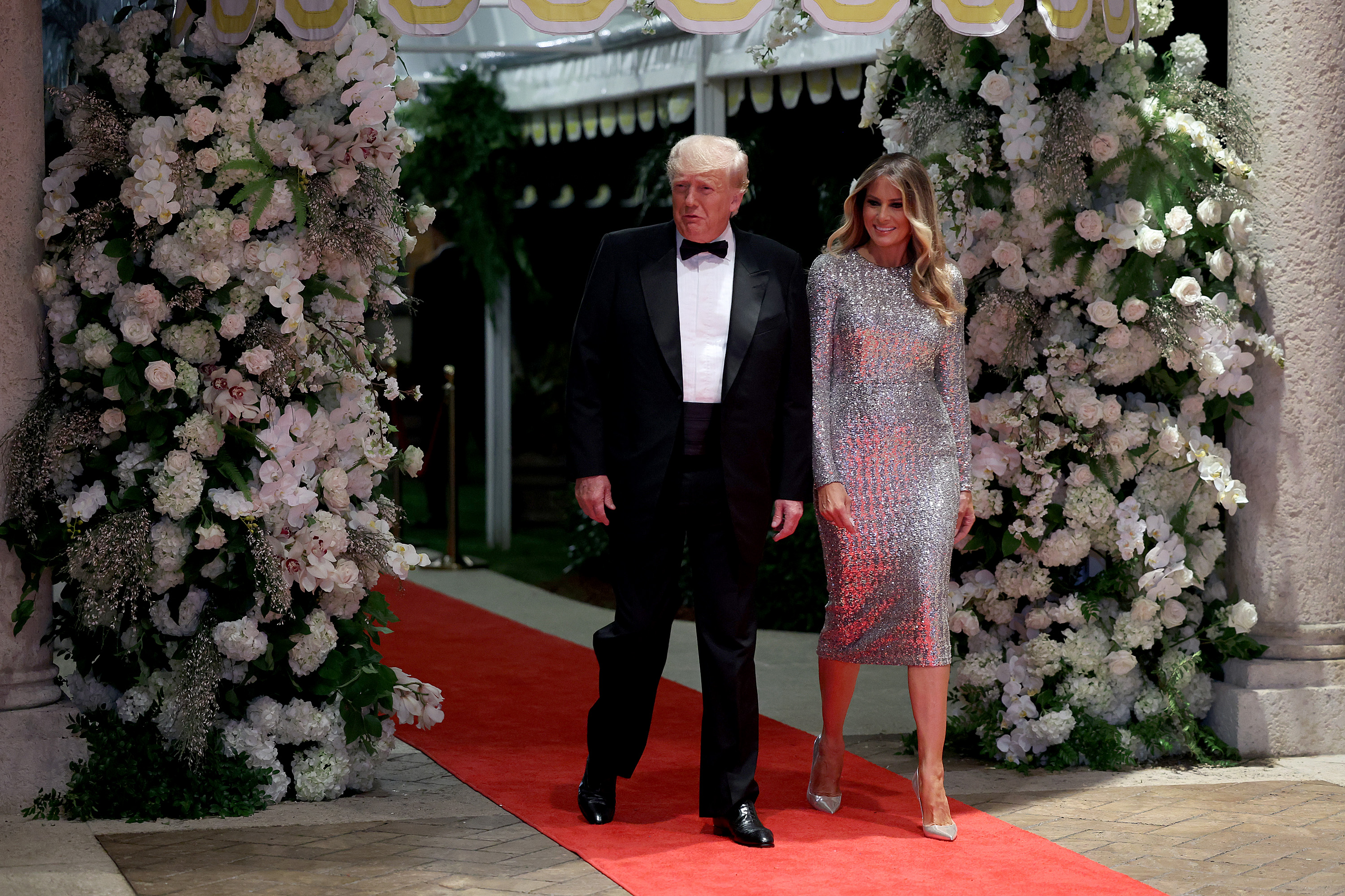 Melania Trump trifft am 31. Dezember 2022 zur Silvesterfeier im Mar-a-Lago in Palm Beach, Florida, ein. Sie trägt ein schimmerndes, silbernes Midikleid mit Pailletten sowie silberne, spitz zulaufende Stiletto-Pumps, die ihre Abendgarderobe mit ihren nadeldünnen Absätzen optisch verlängern.