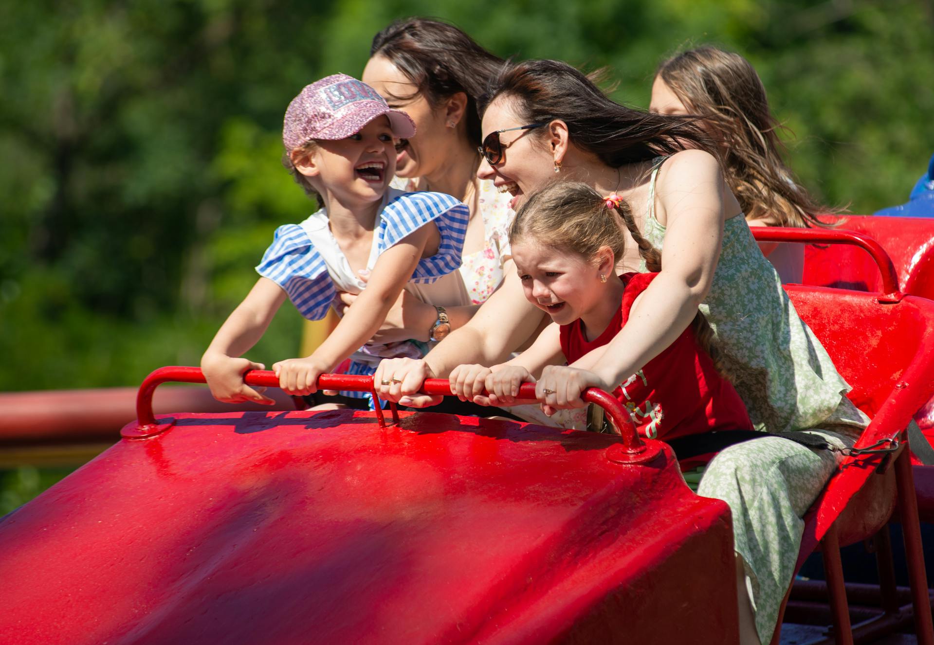 Frauen und Kinder auf einer Achterbahn in einem Vergnügungspark | Quelle: Pexels