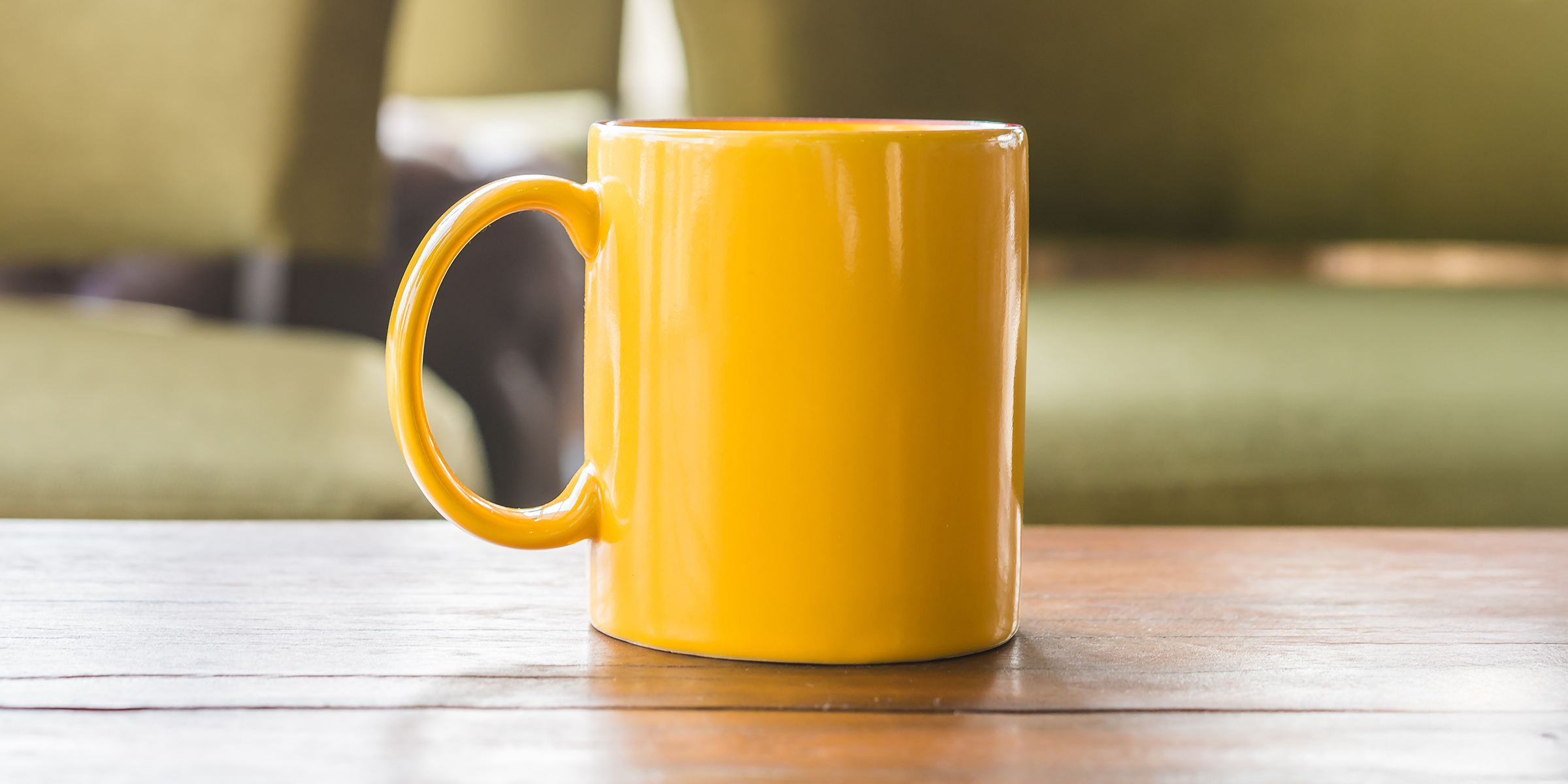 Ein gelber Becher auf einem Tisch | Quelle: Shutterstock