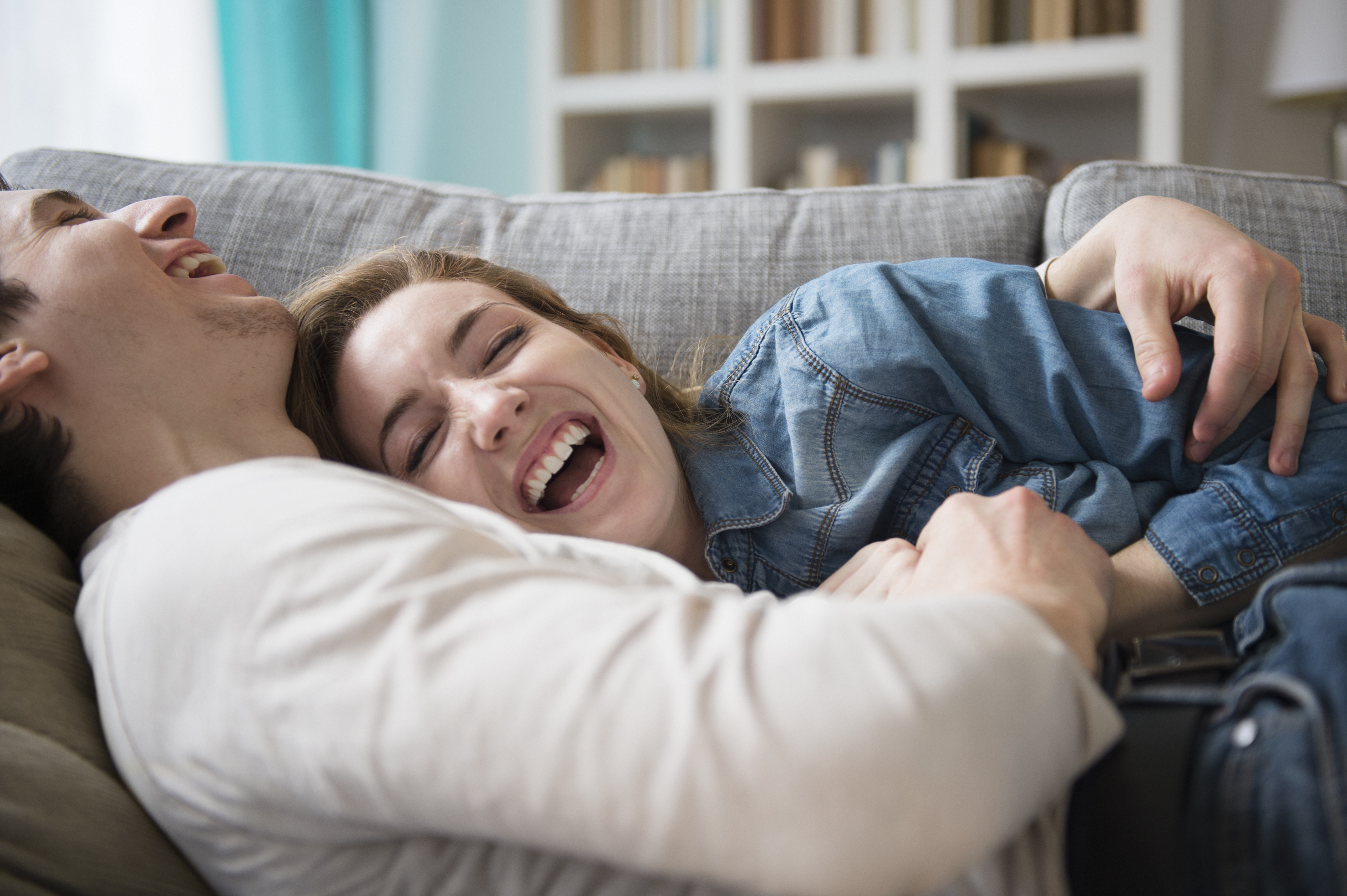 Ein lachendes Paar auf der Couch | Quelle: Getty Images