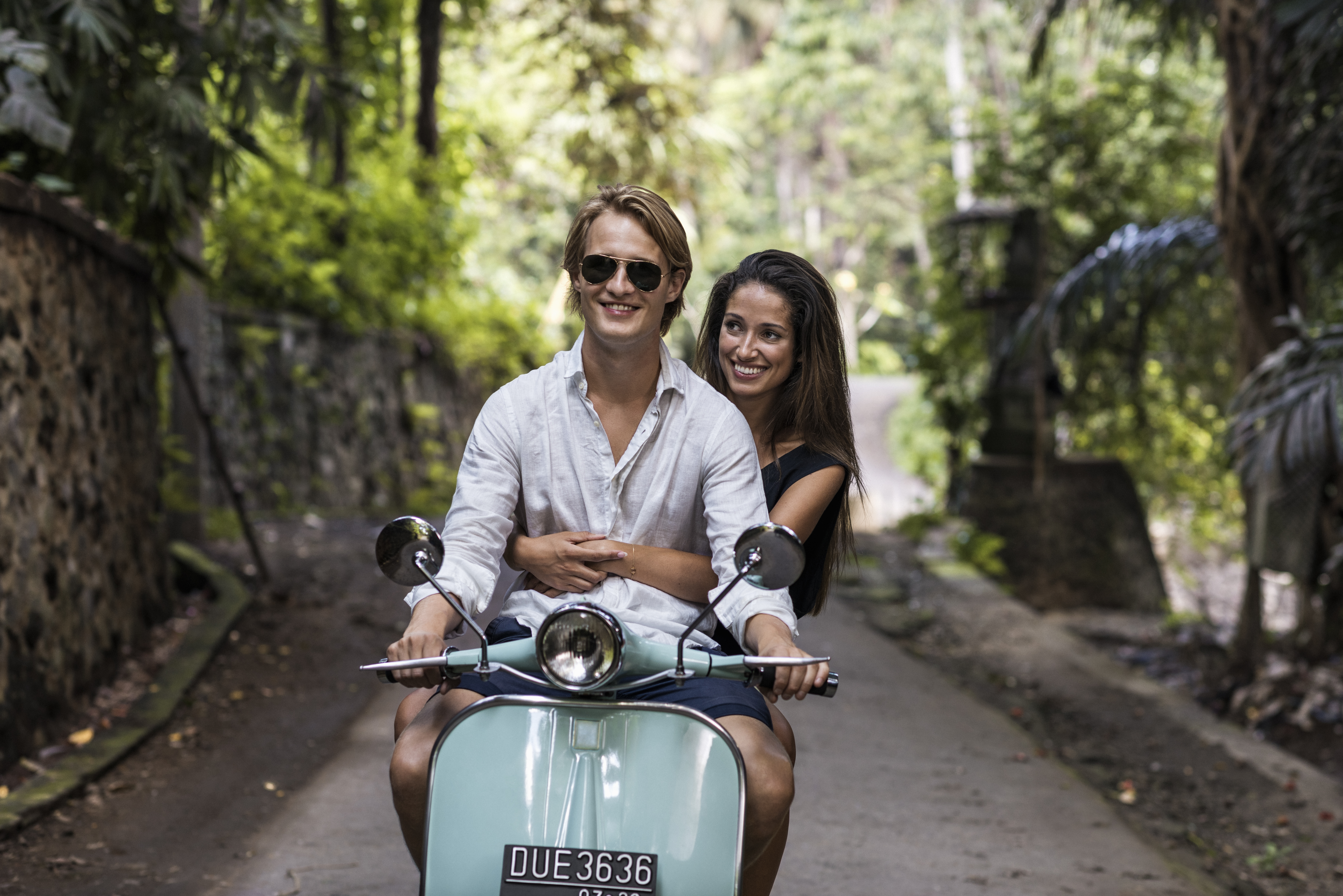 Junges Paar fährt im Urlaub auf Bali auf einem klassischen Motorroller | Quelle: Getty Images