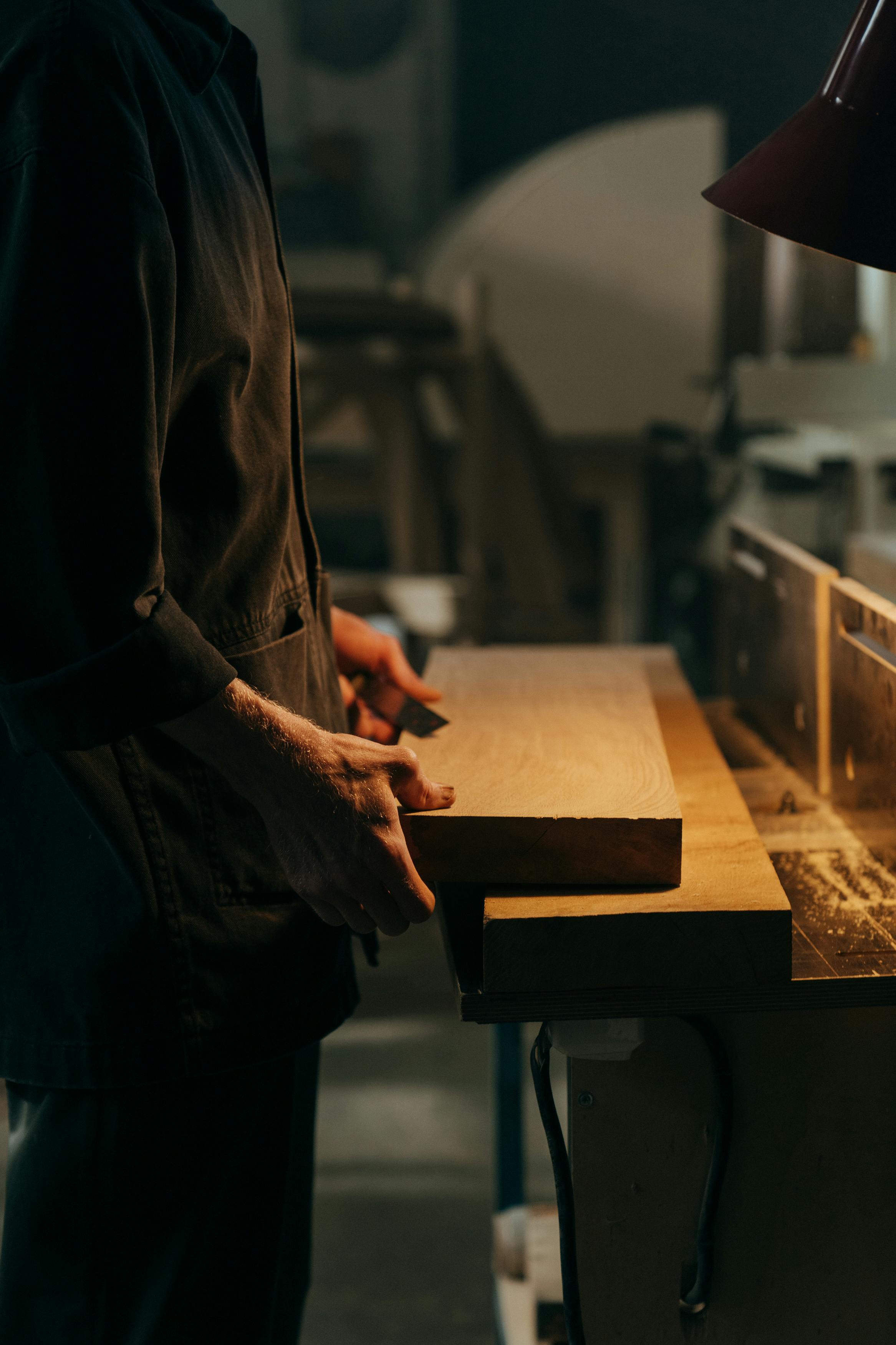 Ein Mann, der Holzplatten hält | Quelle: Pexels