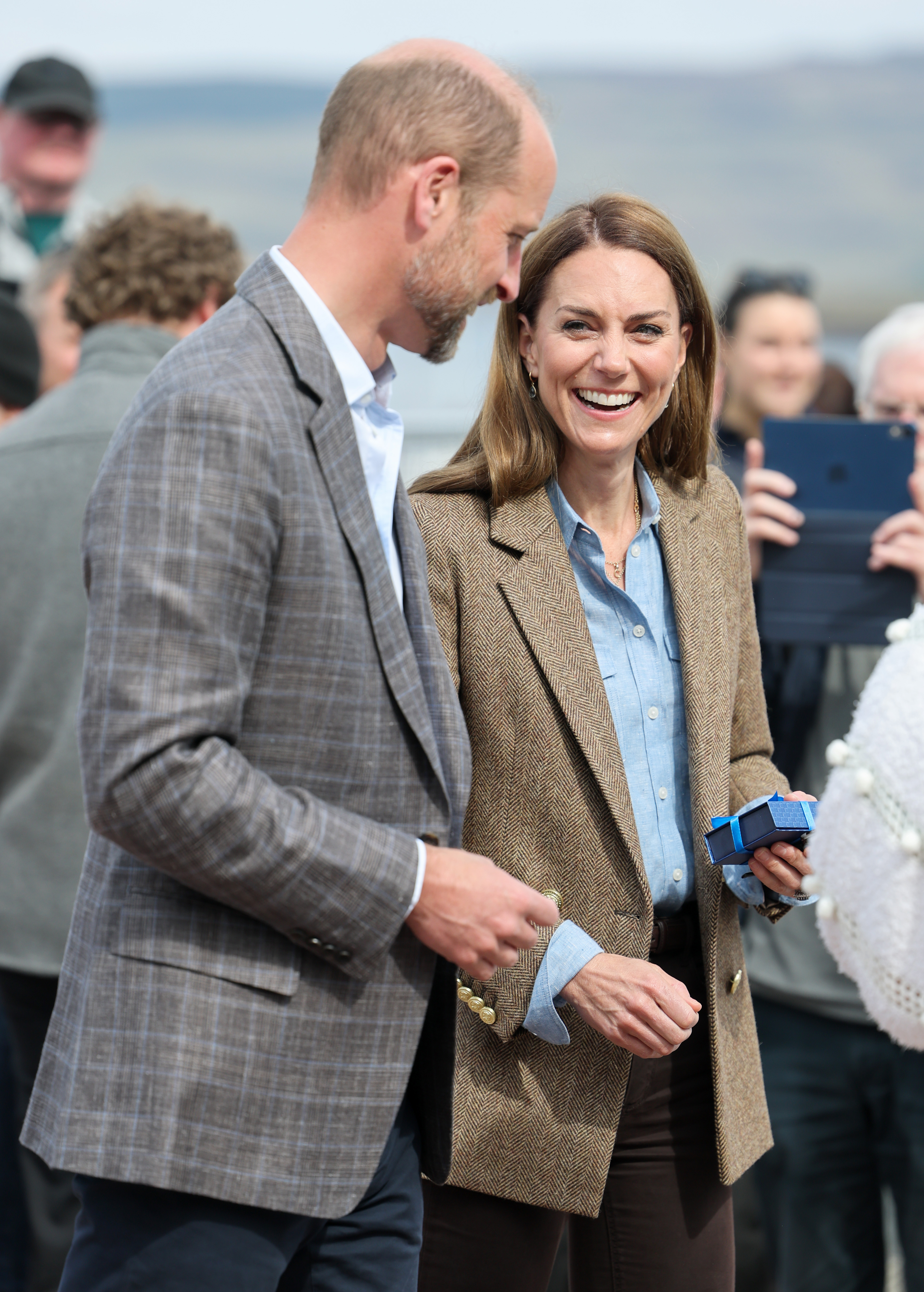 Catherine strahlt, als sie ein kleines Geschenk in der Hand hält, während sie neben William bei einem Gemeindebesuch in Tobermory steht. Das sympathische Auftreten des Paares wurde deutlich, als sie sich bei ihrem Besuch in Aros Hall unter die Bewohner mischten.
