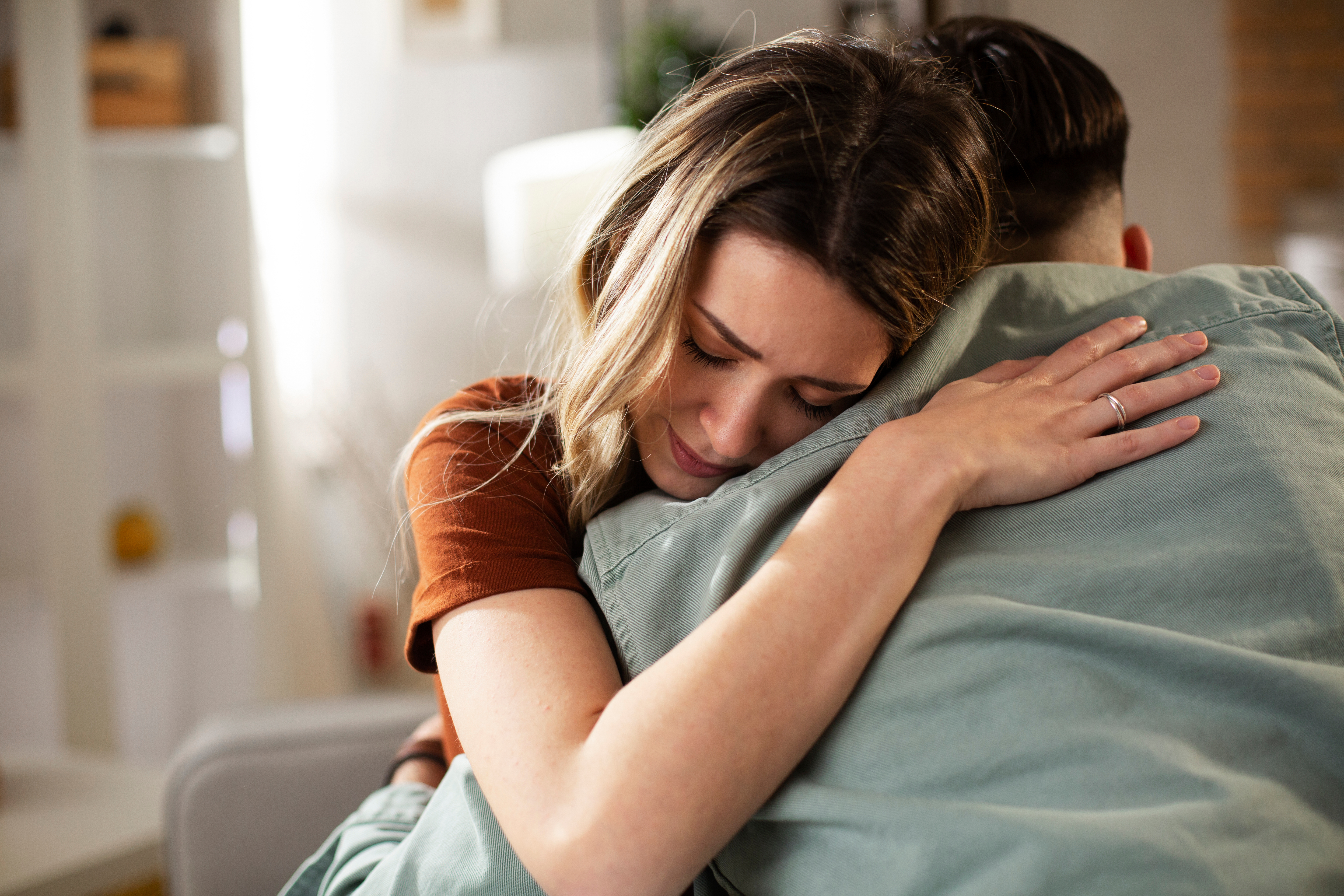 Eine weinende Frau, die ihren Mann umarmt | Quelle: Shutterstock